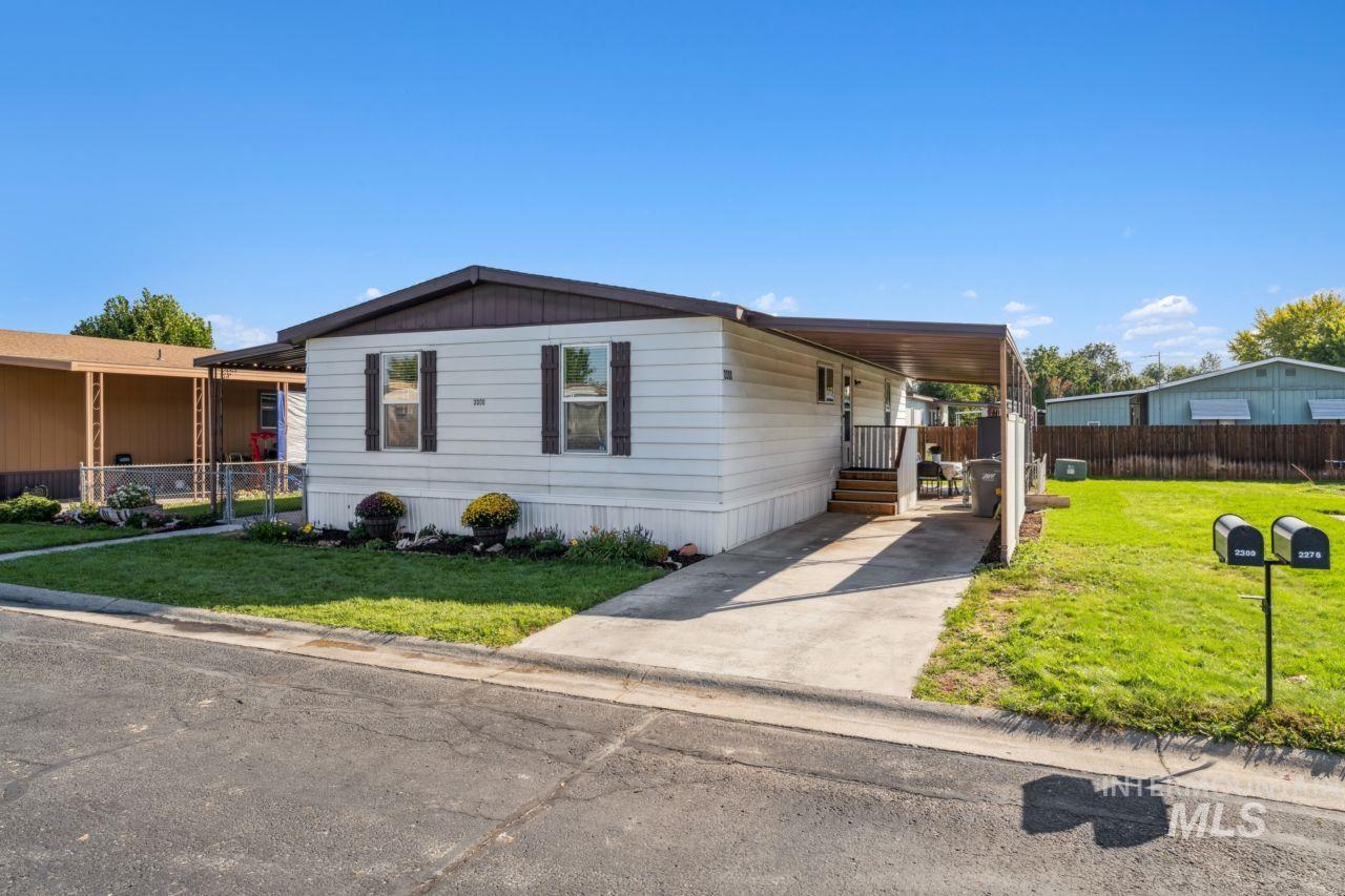Manufactured / mobile home featuring a carport and driveway