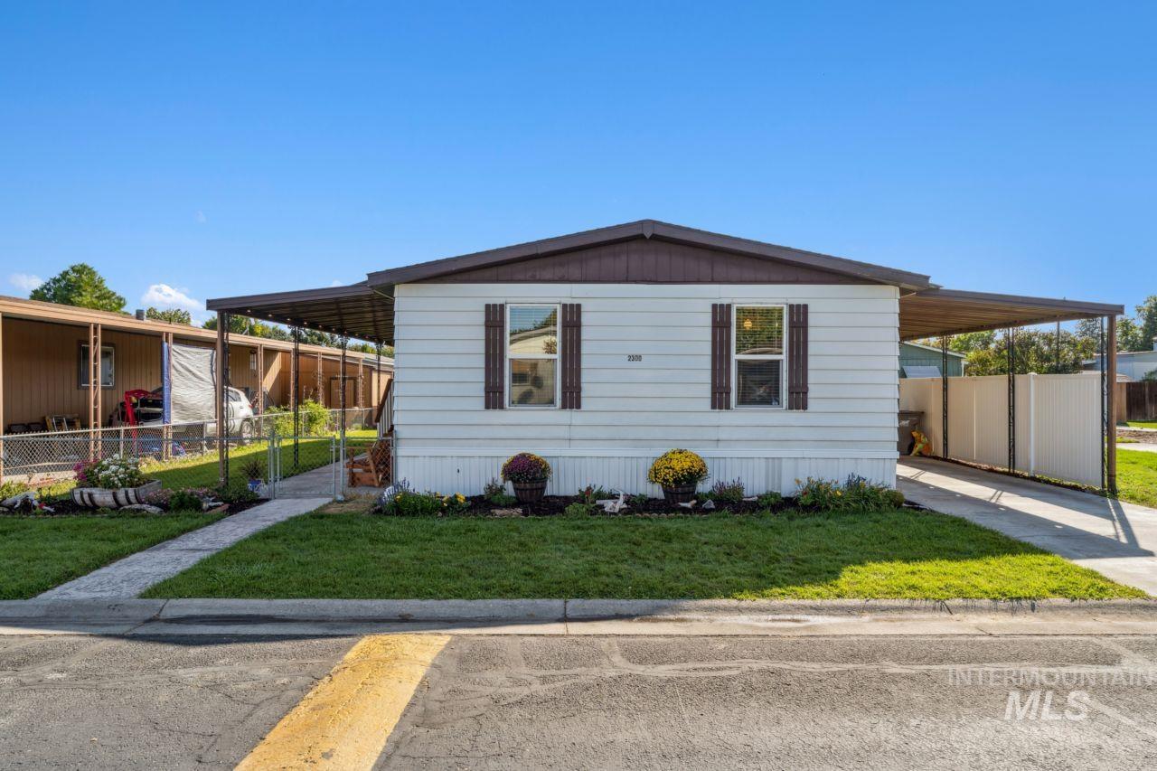 View of front of property with an attached carport and concrete driveway