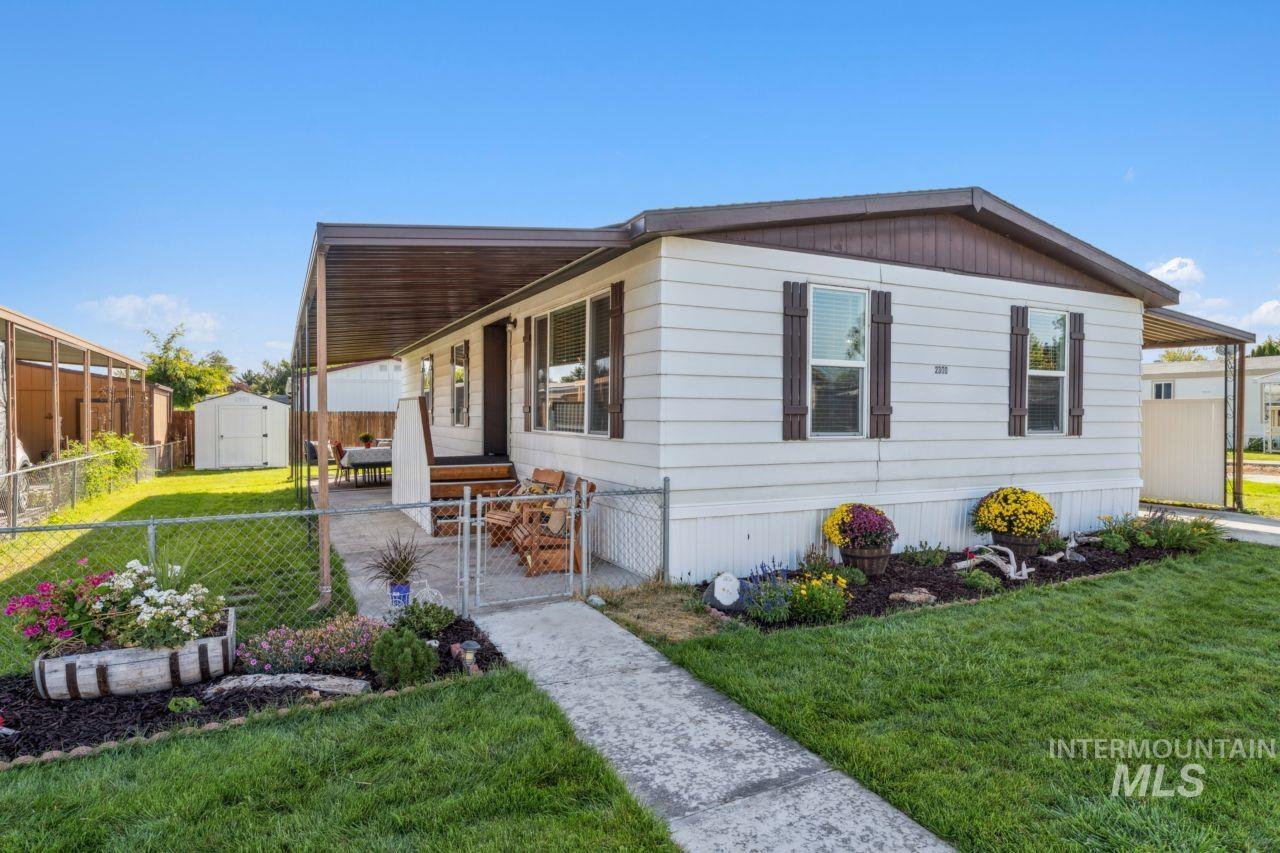 View of side of home with a gate, a storage unit, and covered porch
