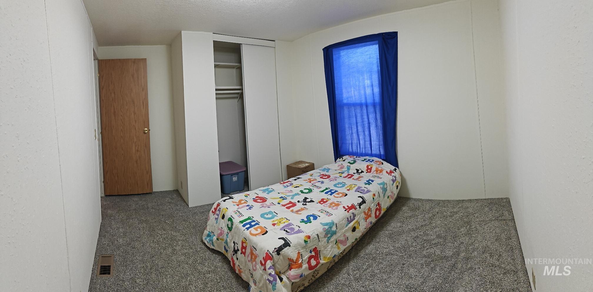 Bedroom featuring a closet, carpet floors, and a textured ceiling