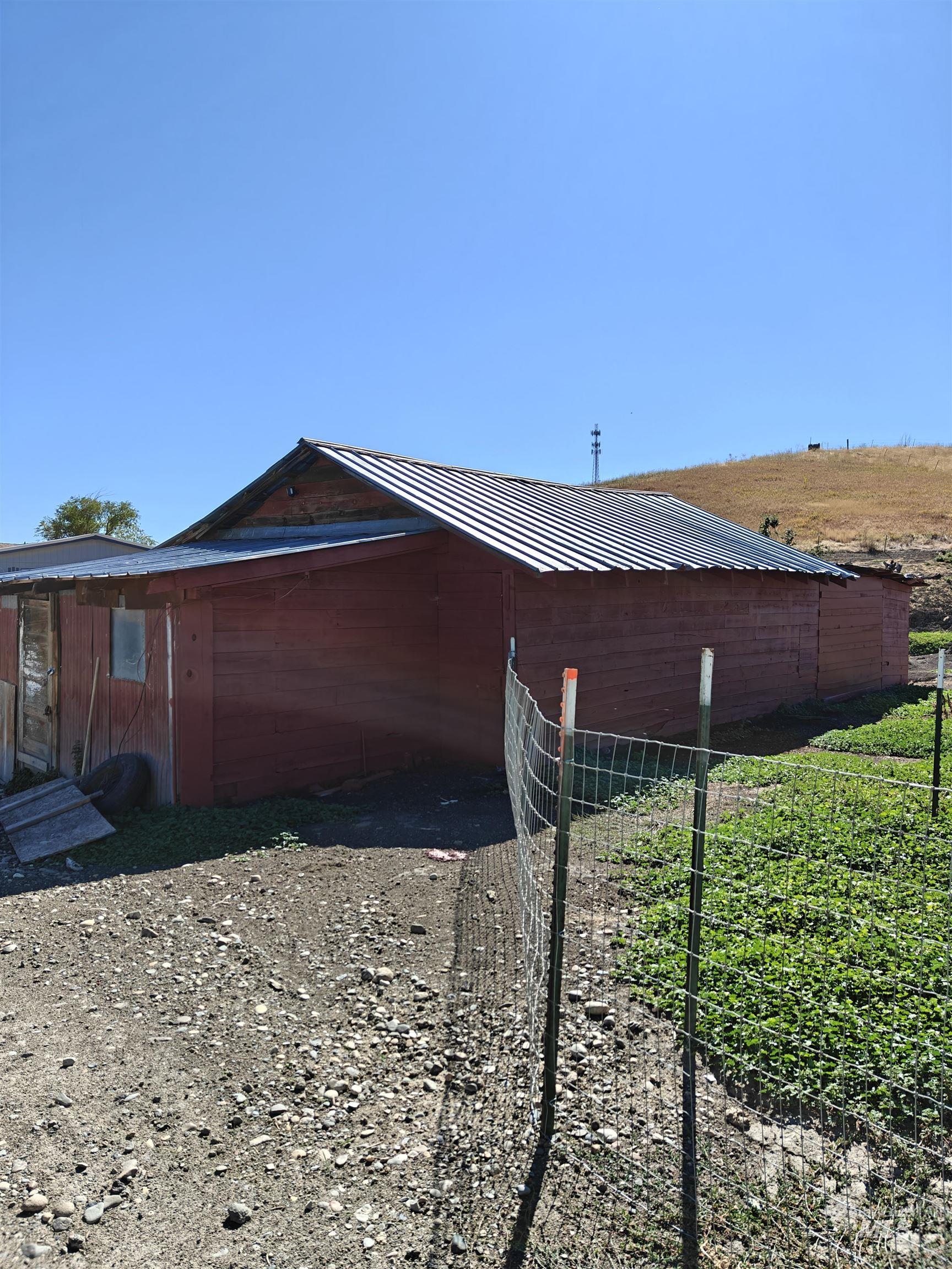 View of property exterior with a metal roof and an outdoor structure
