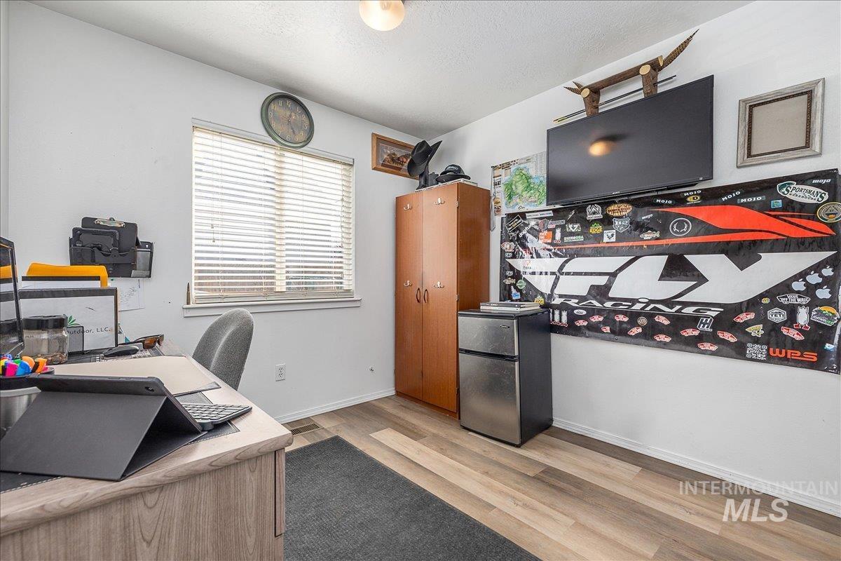 Additional bedroom is currently being used as home office and features the same light wood-style flooring.