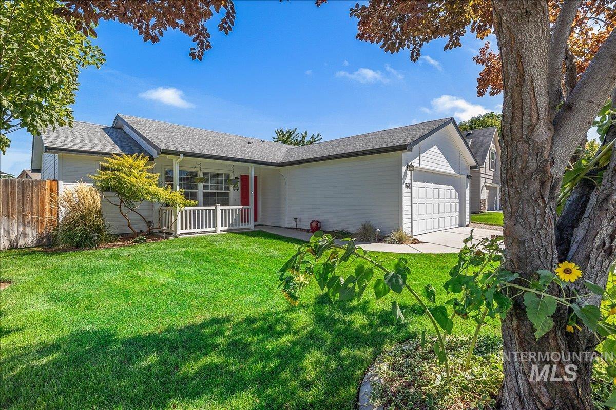 Ranch-style home featuring an attached 2-car garage, shingle roof and large concrete driveway.