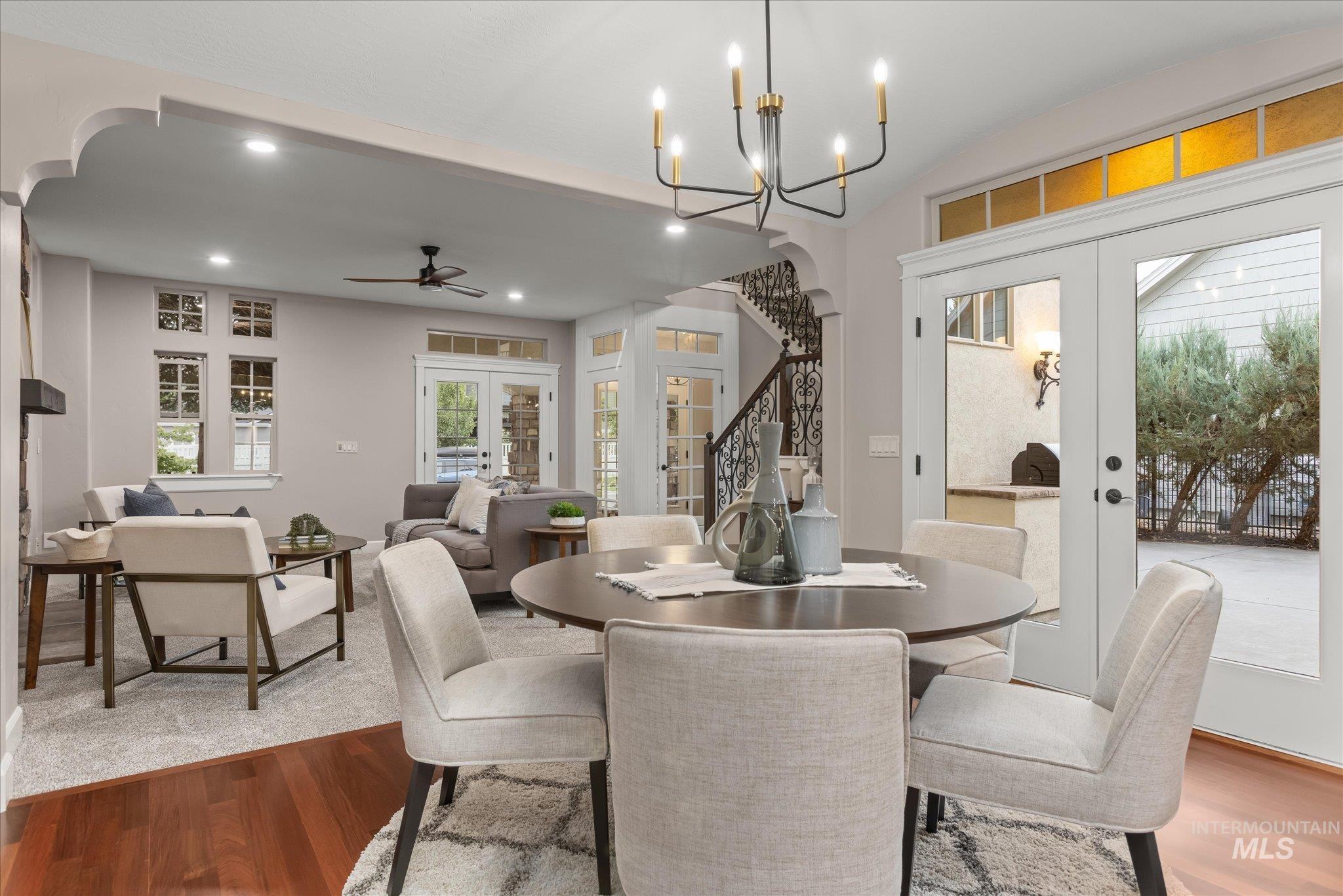 Dining area with french doors, arched walkways, stairs, wood finished floors, and recessed lighting