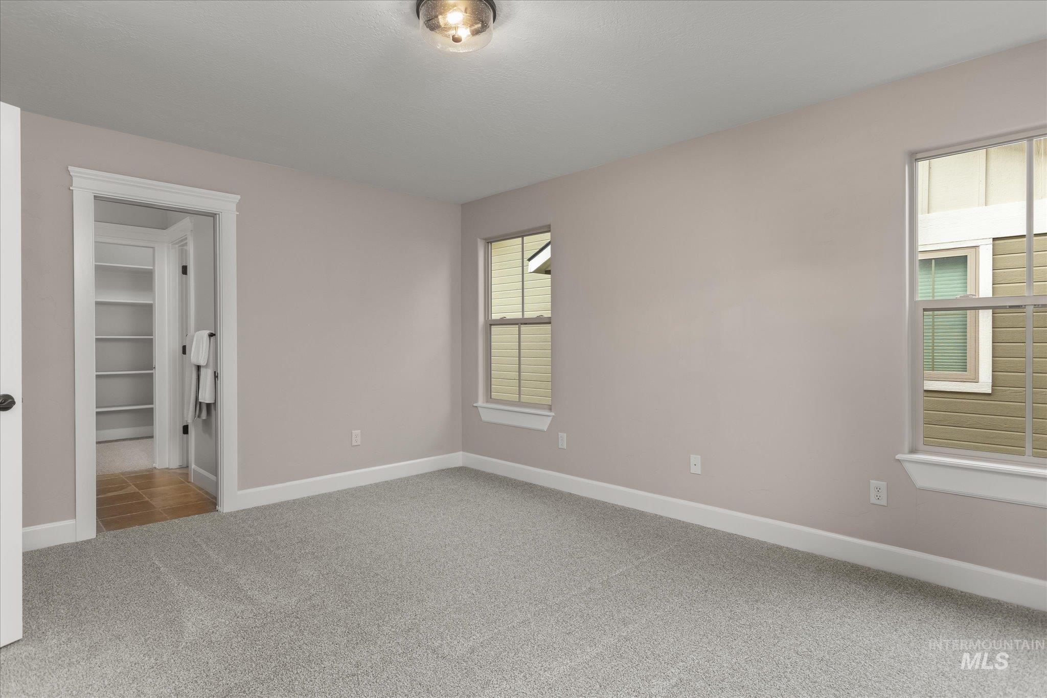 Unfurnished bedroom featuring light colored carpet and a spacious closet
