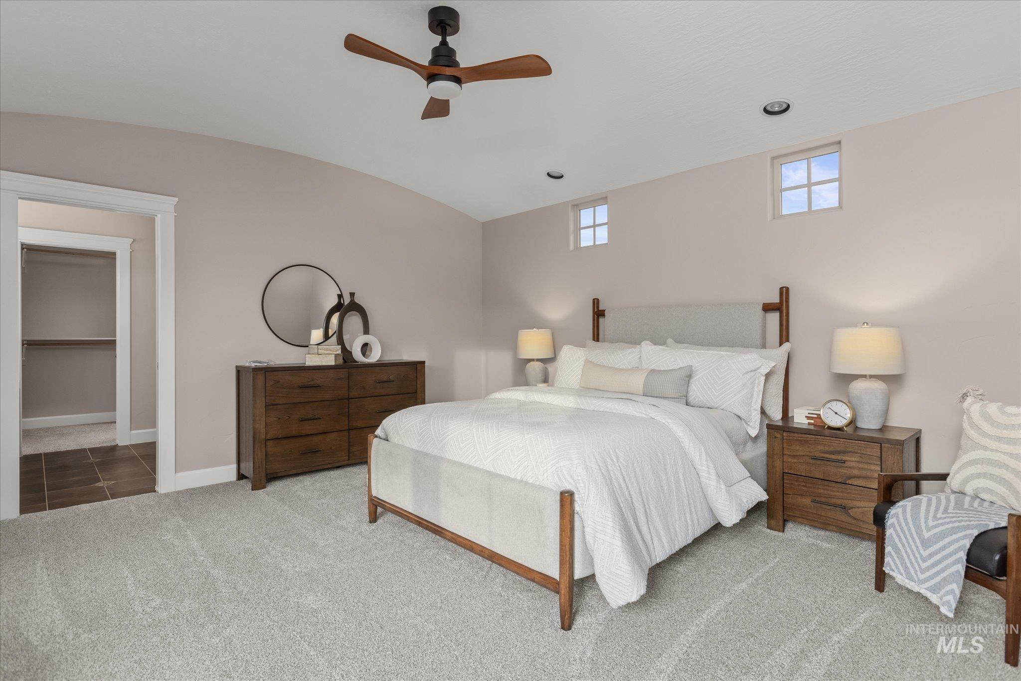 Bedroom featuring carpet floors, ceiling fan, and vaulted ceiling