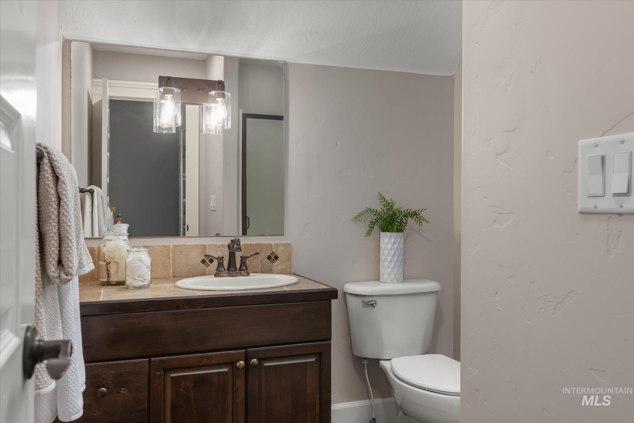 Full bathroom with vanity and a textured wall