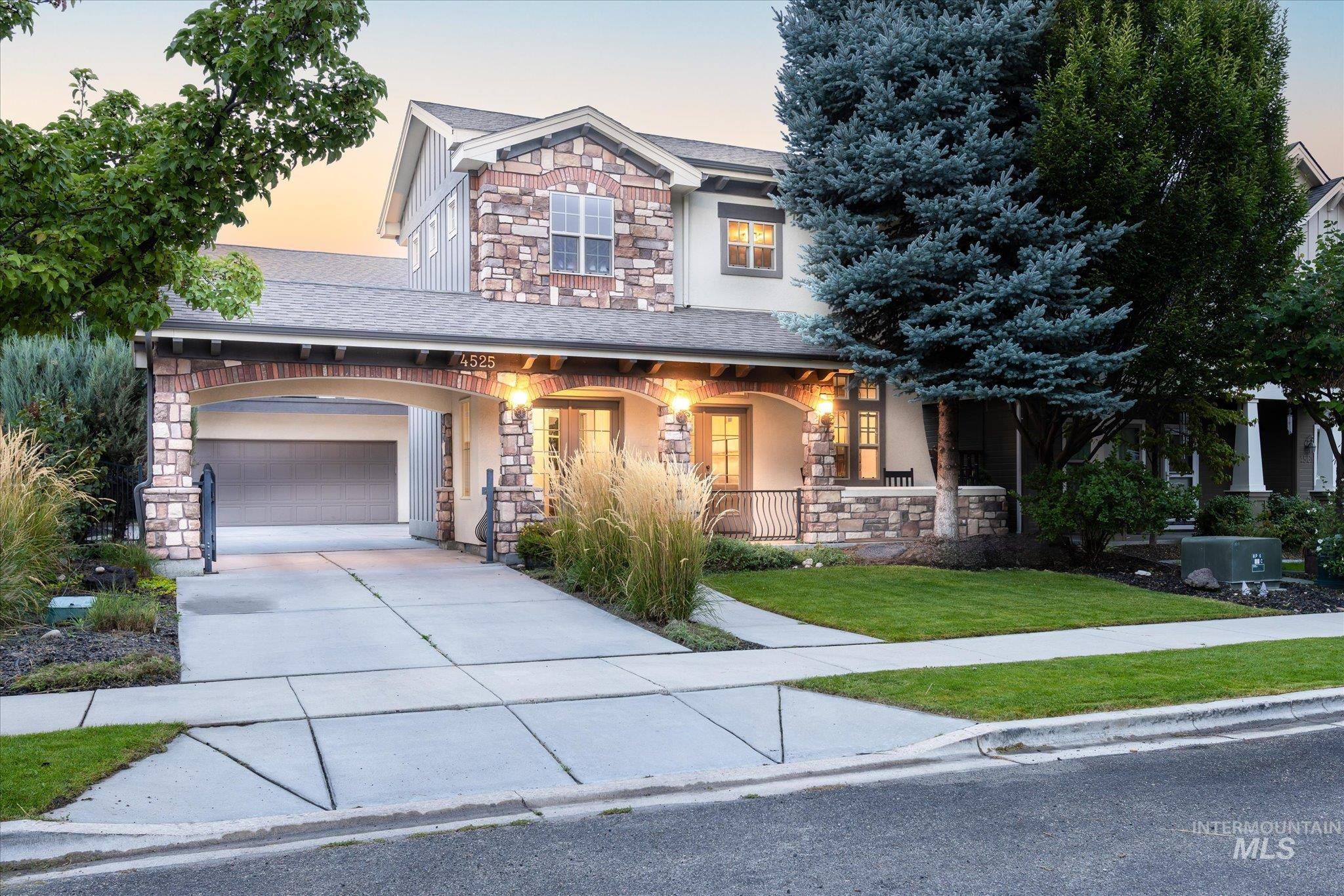 Craftsman-style home featuring stone siding, a porch, concrete driveway, and roof with shingles