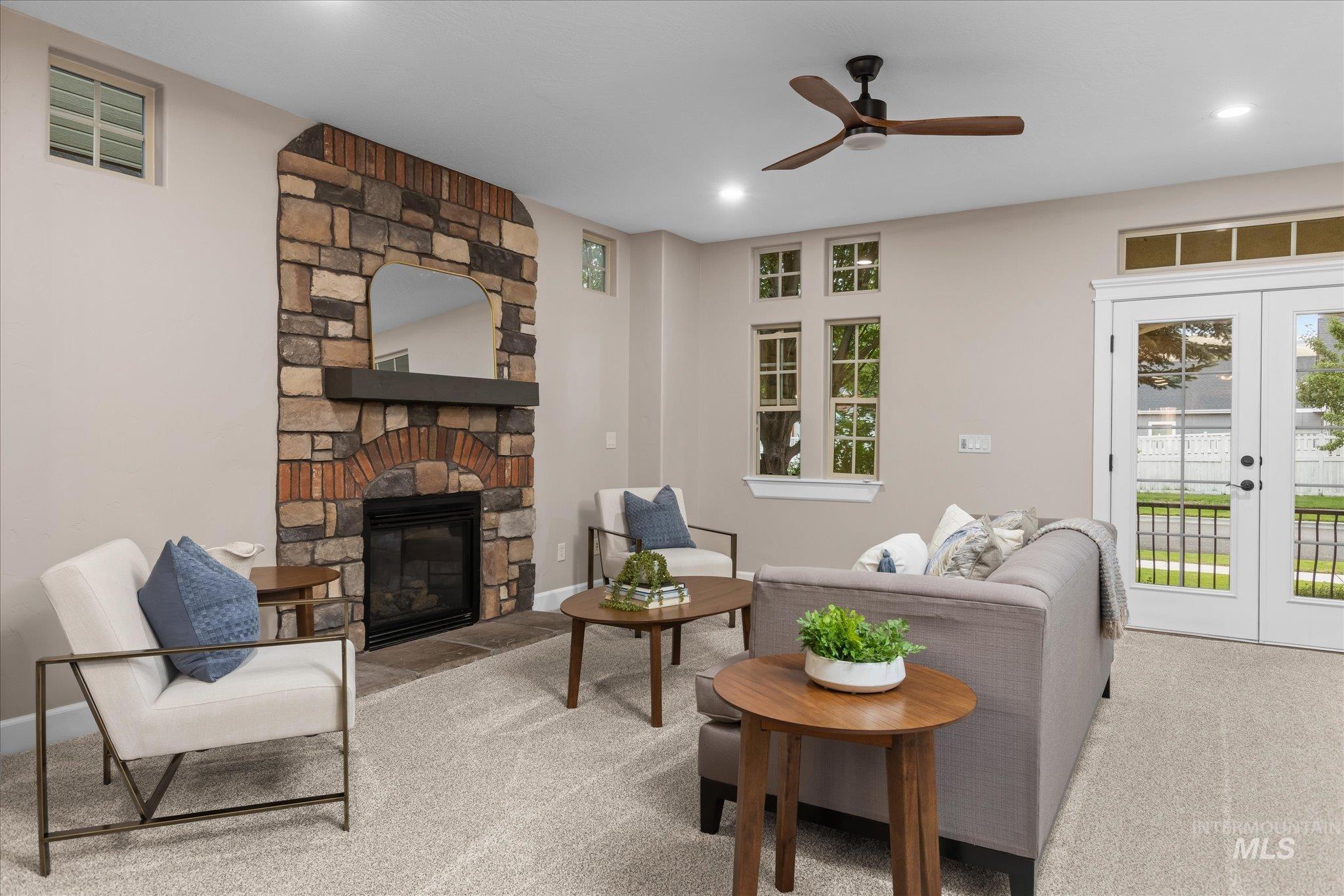 Living room featuring carpet flooring, a fireplace, ceiling fan, french doors, and recessed lighting