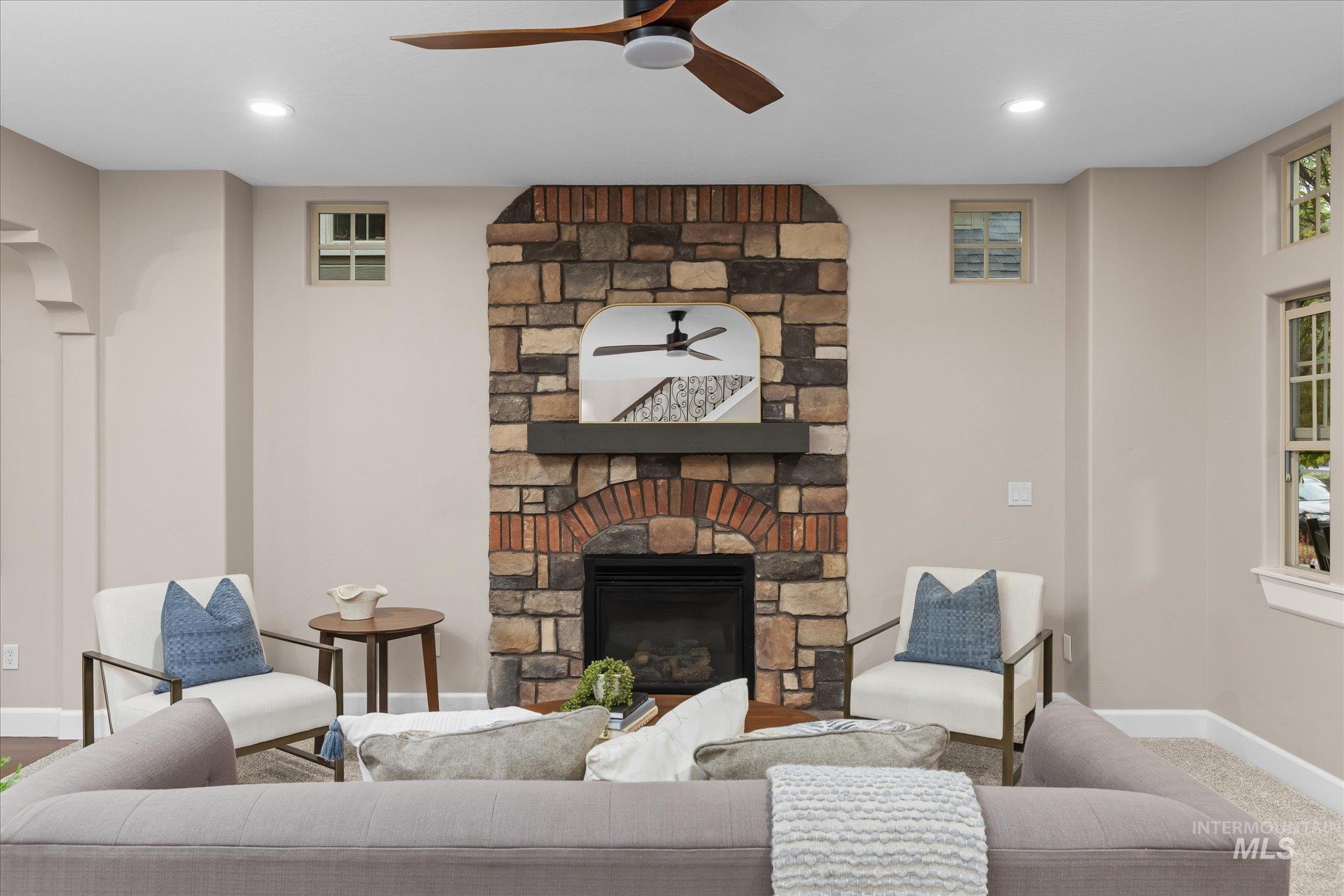 Carpeted living area with a ceiling fan, a fireplace, and recessed lighting