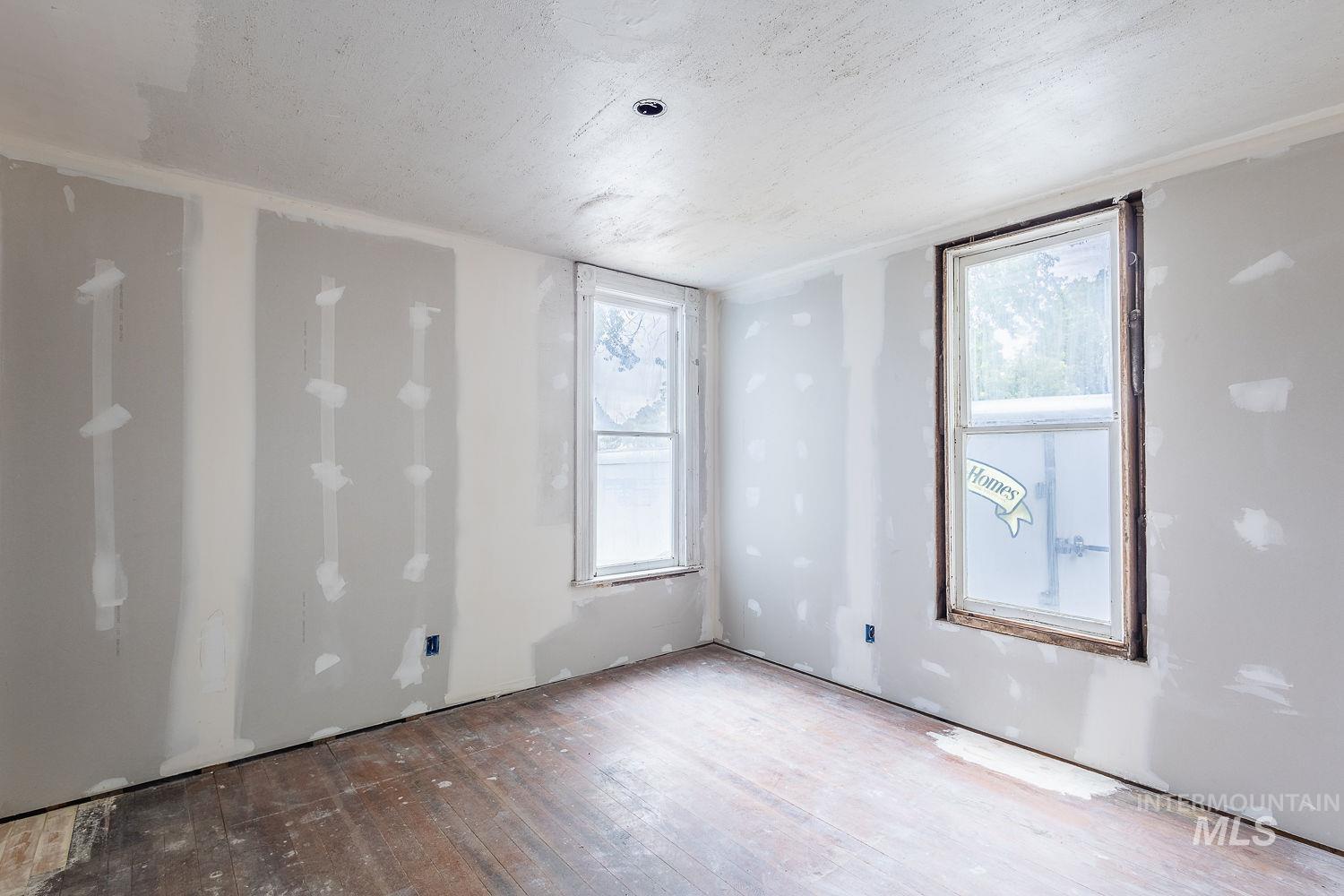Unfurnished room with a textured ceiling and hardwood / wood-style flooring