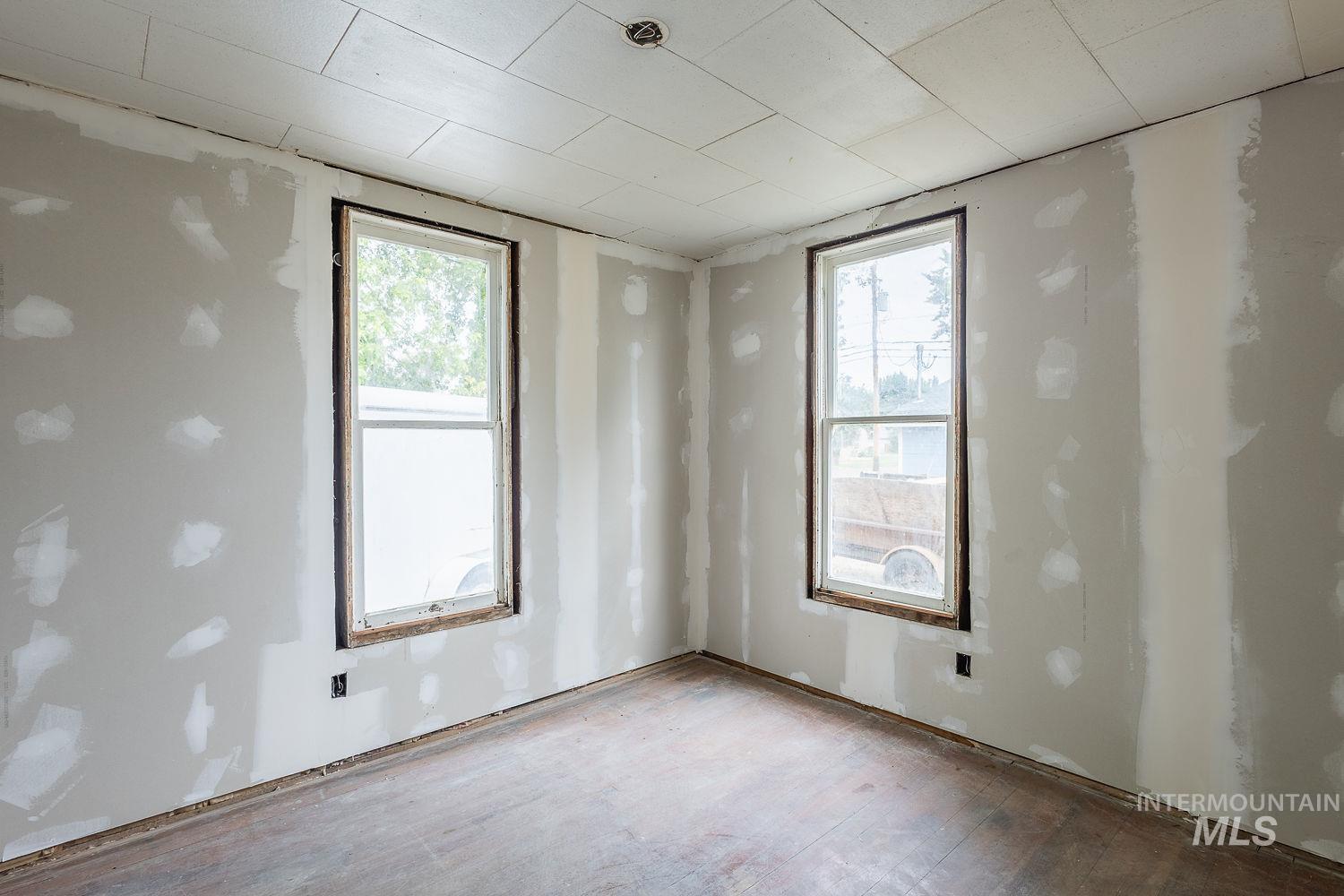 Spare room featuring healthy amount of natural light and wood finished floors
