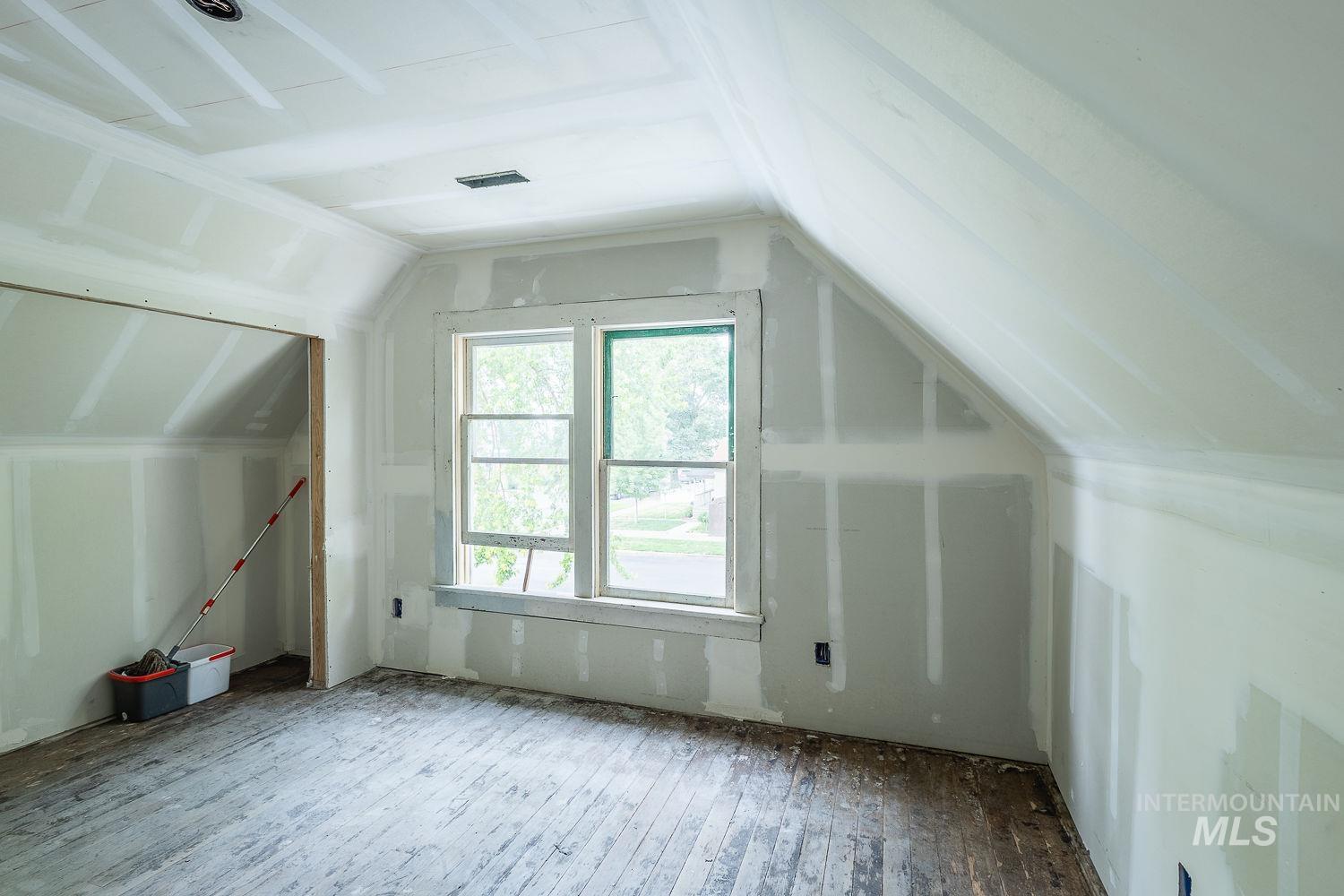 Additional living space featuring lofted ceiling and wood-type flooring