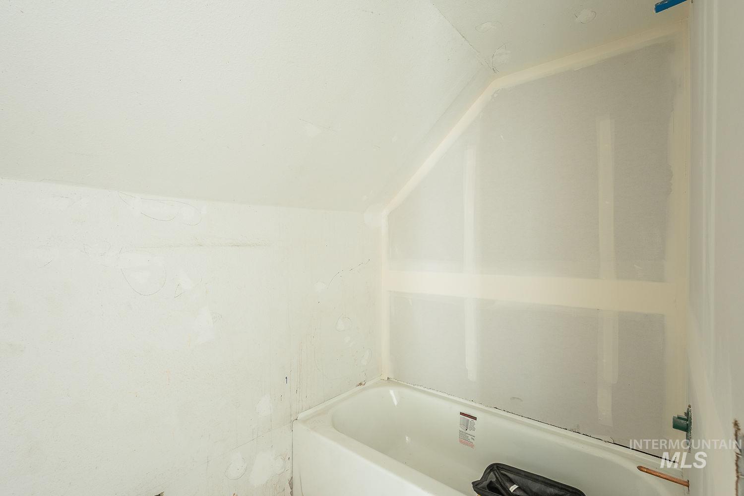 Full bathroom with lofted ceiling