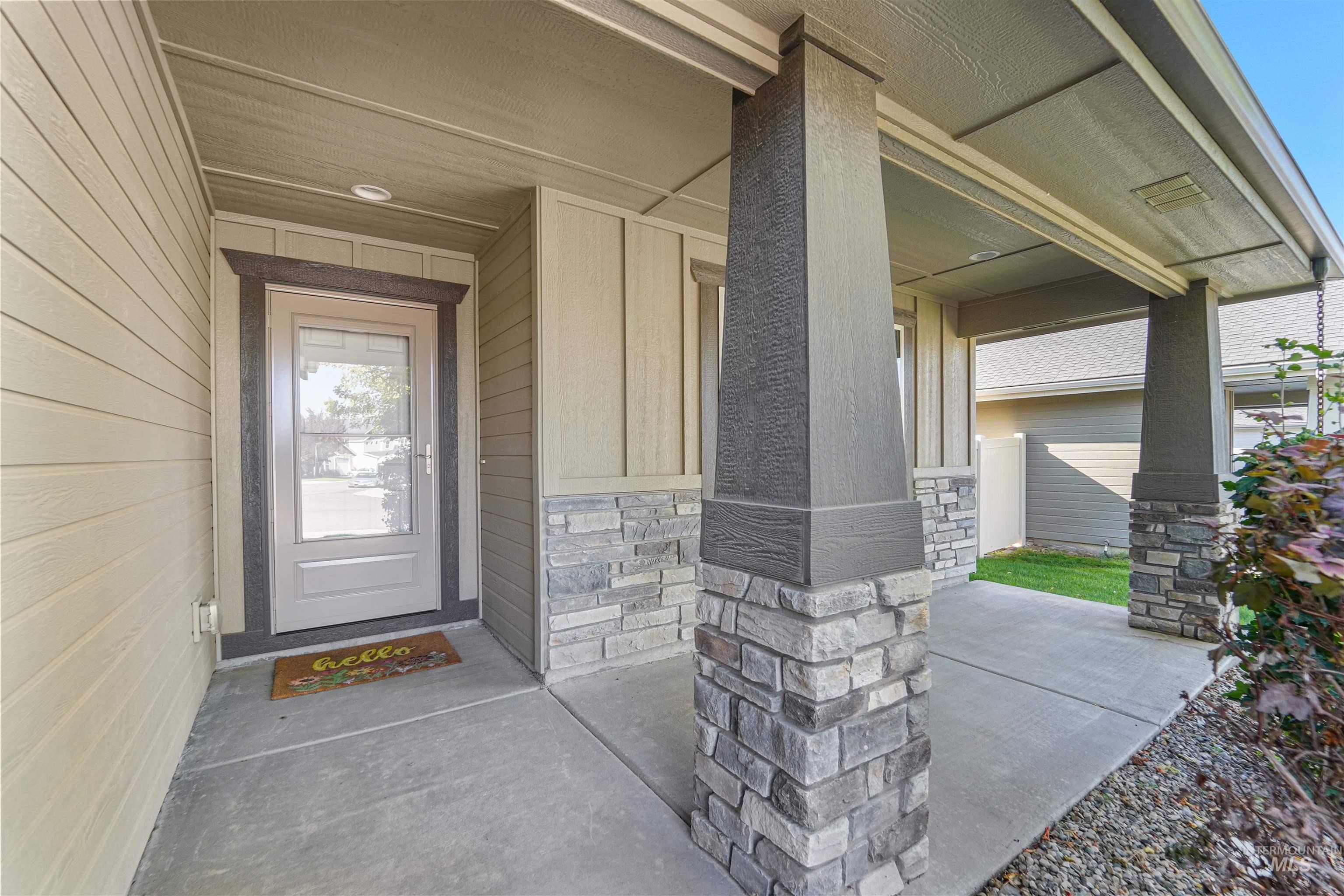 Entrance to property with stone siding and a porch