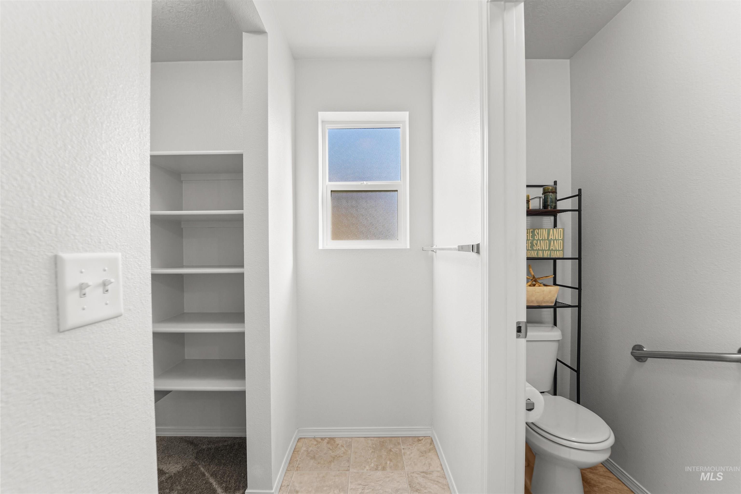 Bathroom featuring a textured ceiling and light tile patterned floors