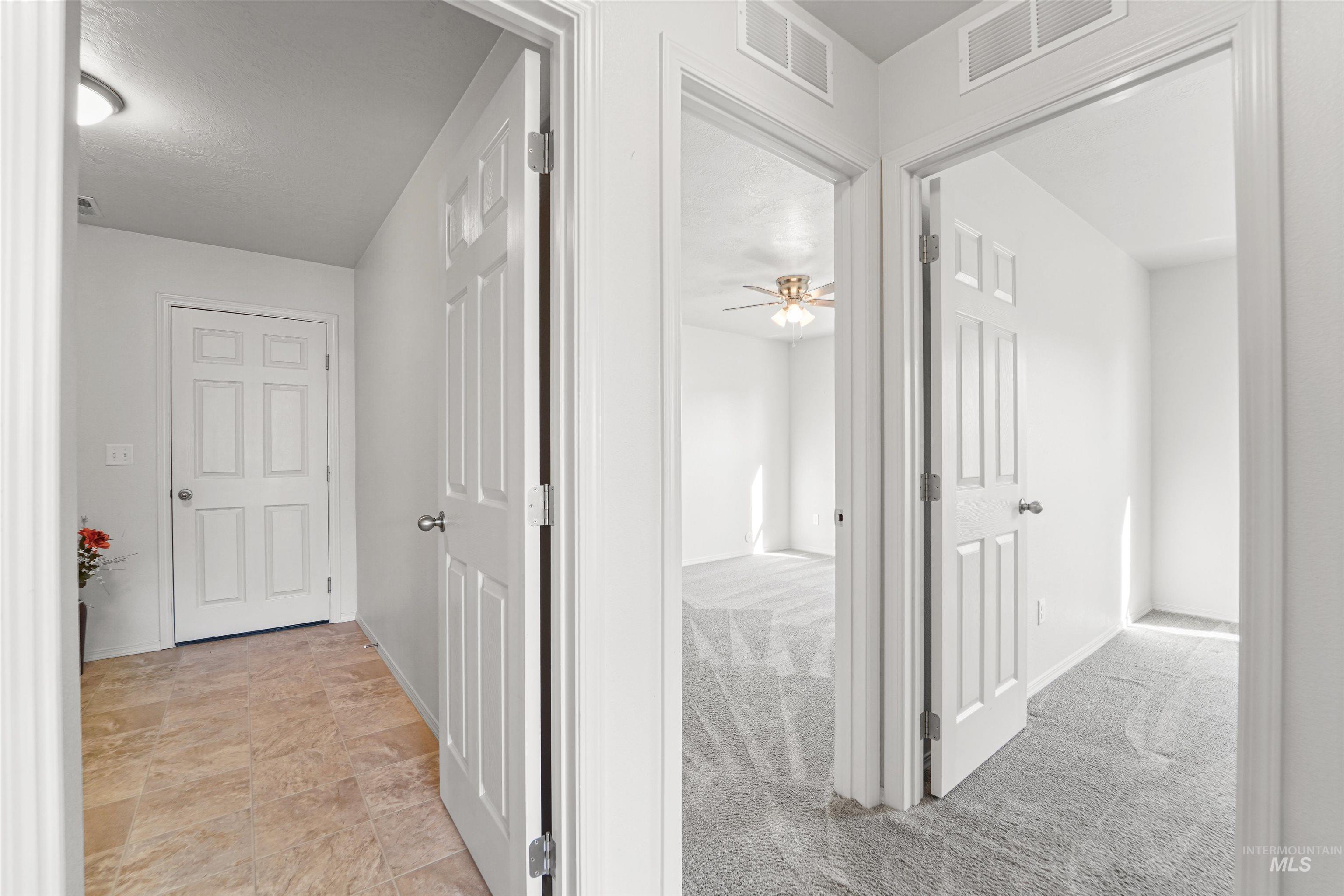 Hallway featuring light colored carpet