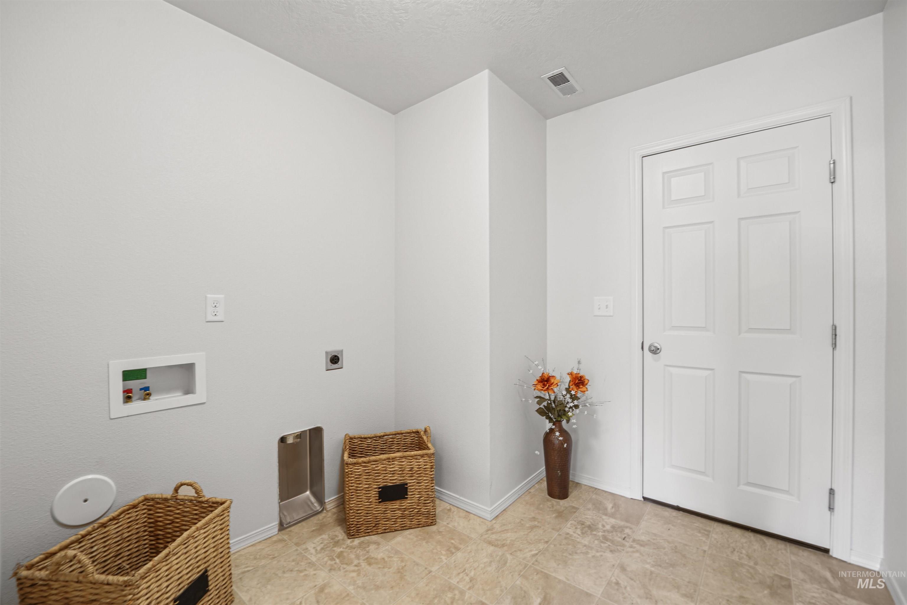 Laundry room with hookup for a washing machine, a textured ceiling, and electric dryer hookup