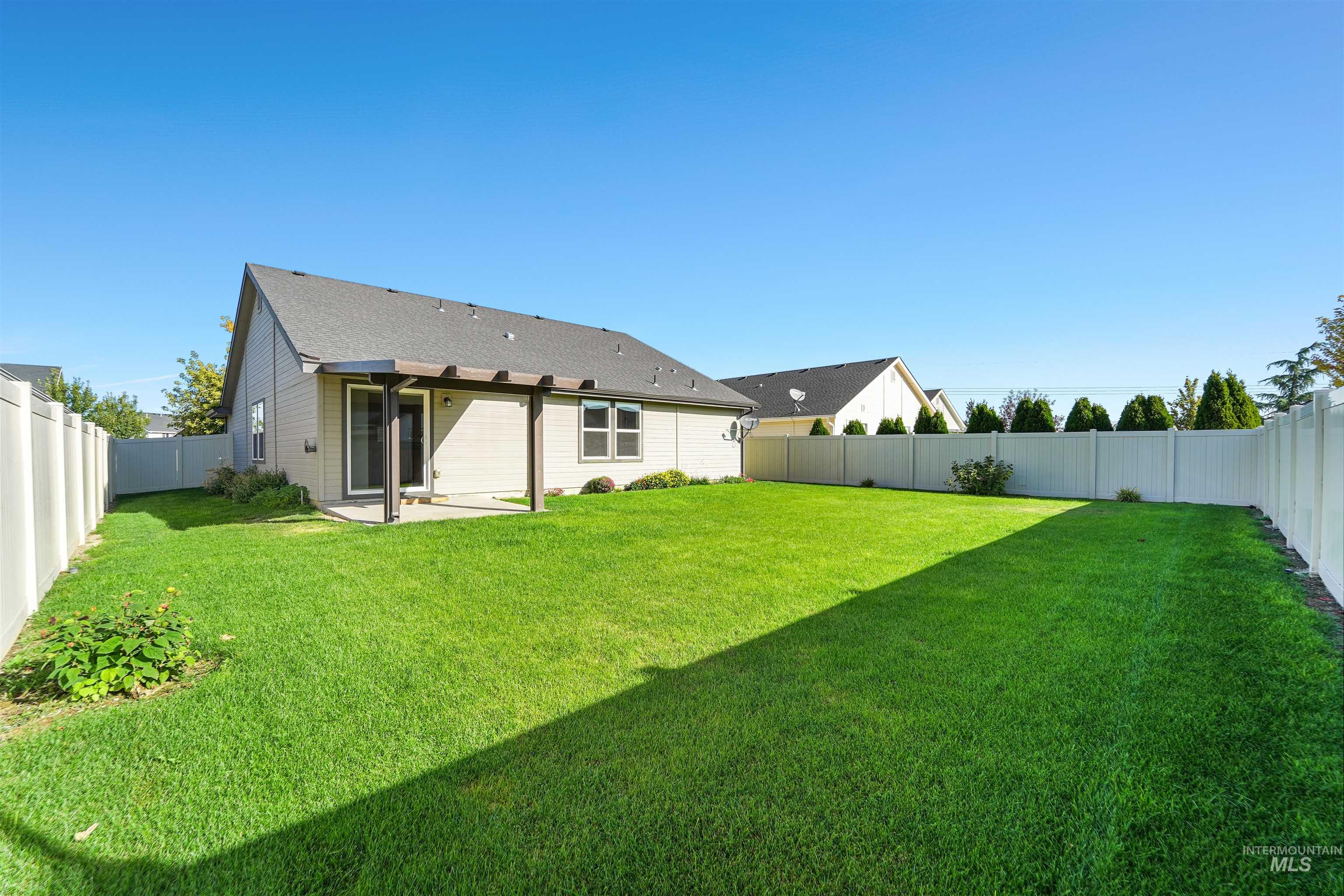 Back of property featuring a patio area, a fenced backyard, and roof with shingles