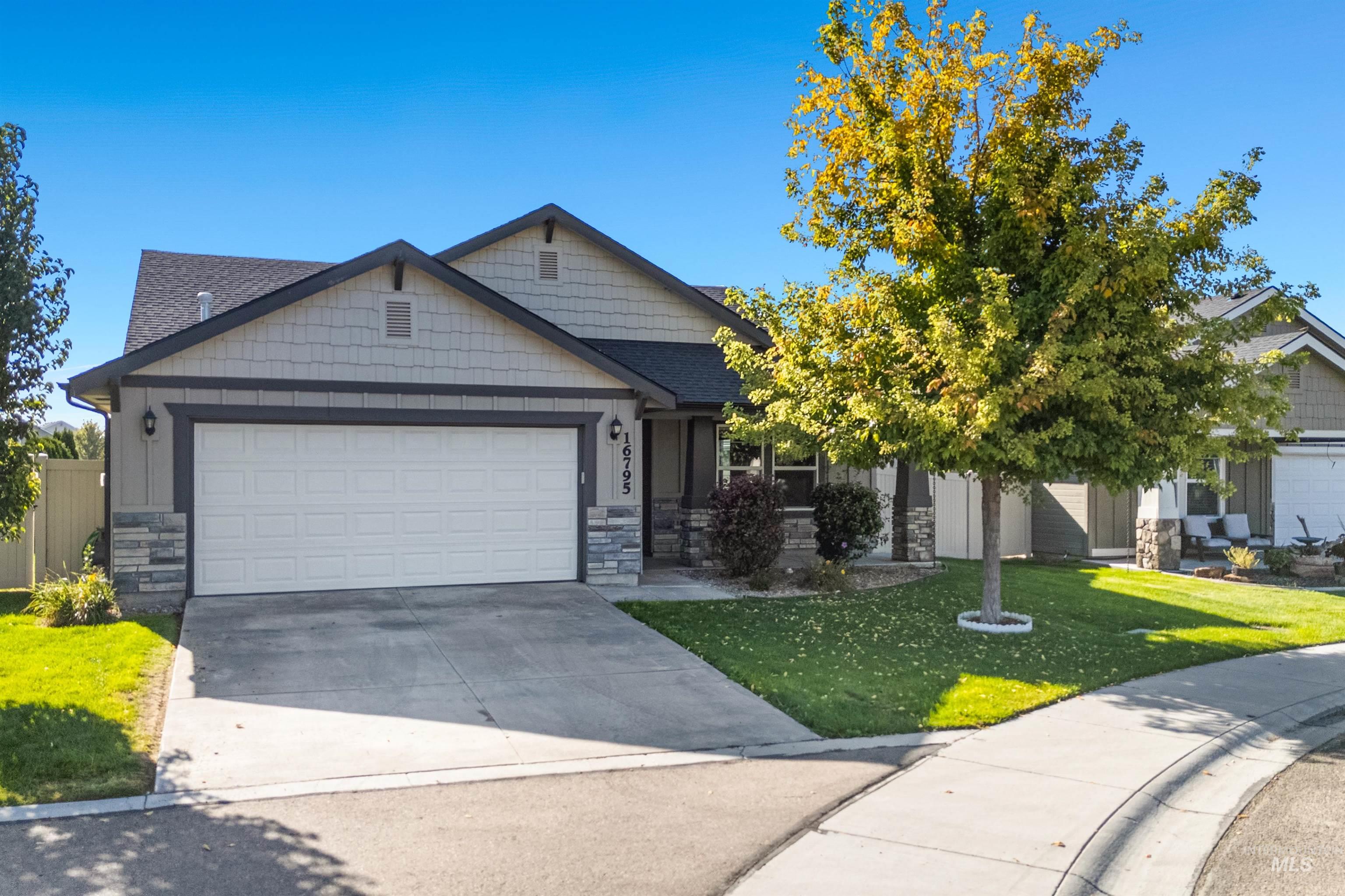 Craftsman house featuring stone siding, concrete driveway, and a garage