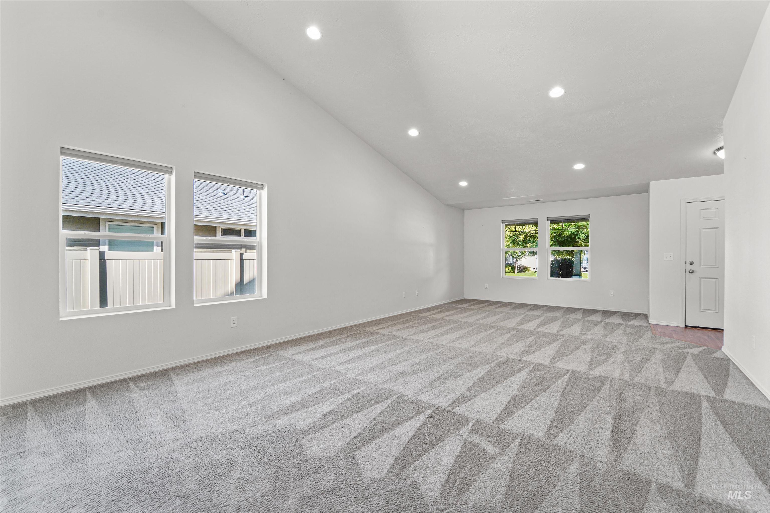 Spare room featuring recessed lighting, light carpet, and high vaulted ceiling