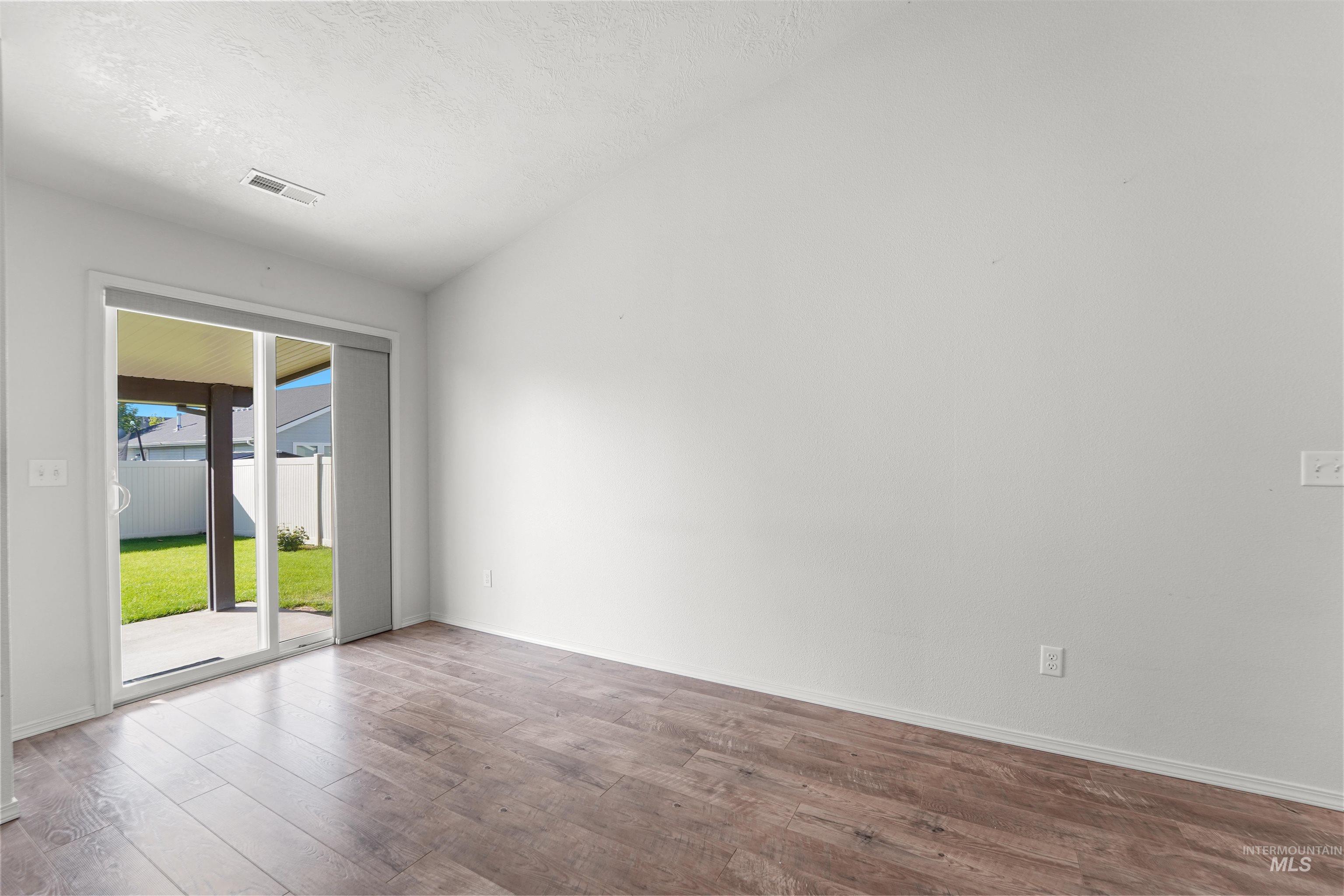 Unfurnished room featuring wood finished floors and a textured ceiling