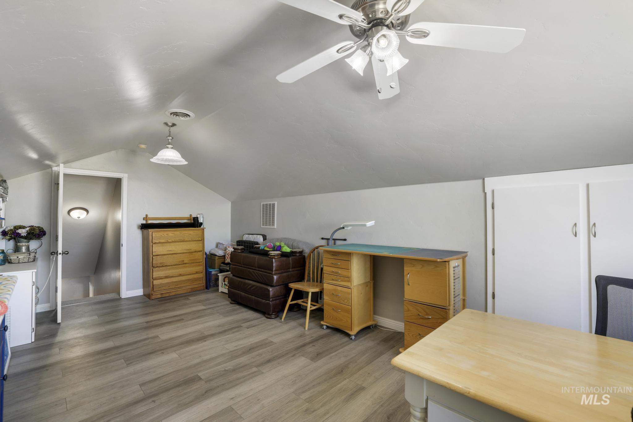 Office area with light wood finished floors and vaulted ceiling