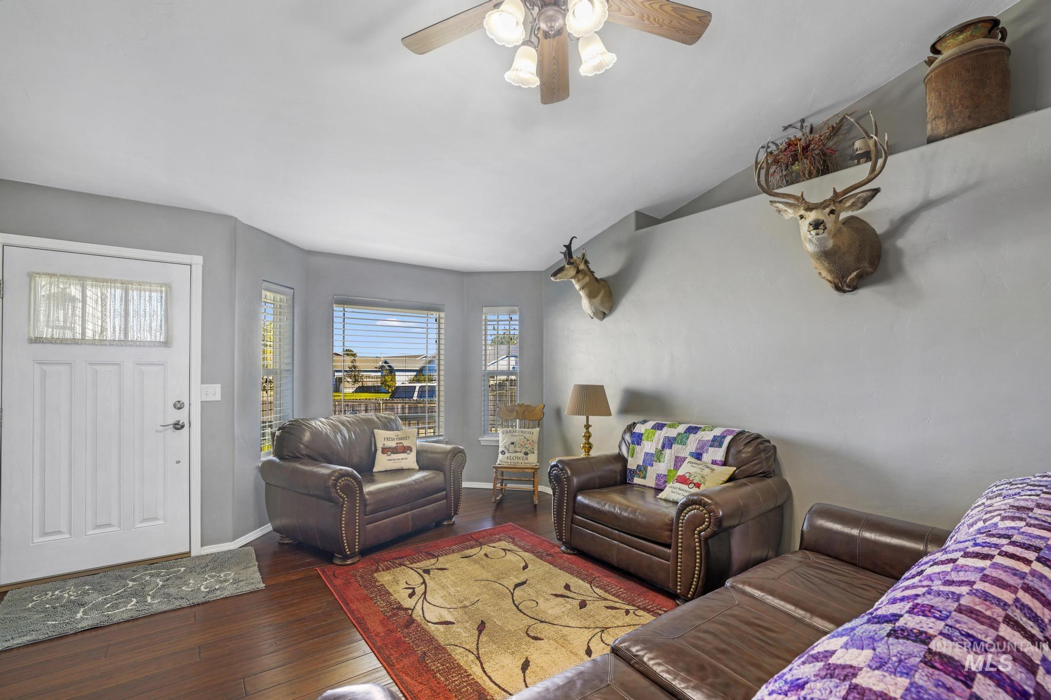 Living area with dark wood-type flooring and ceiling fan