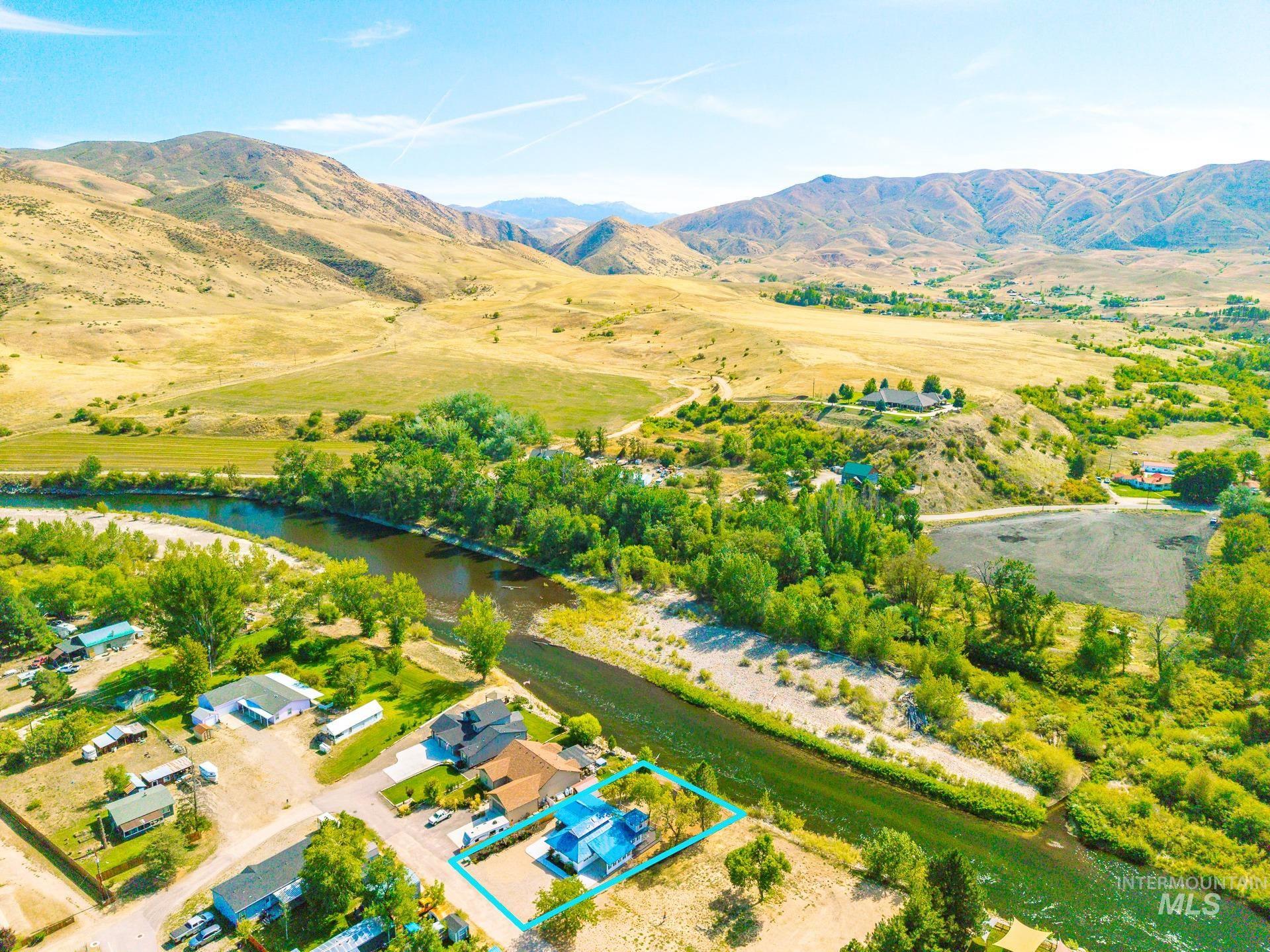 Aerial view of sparsely populated area featuring property boundaries highlighted and a water and mountain view