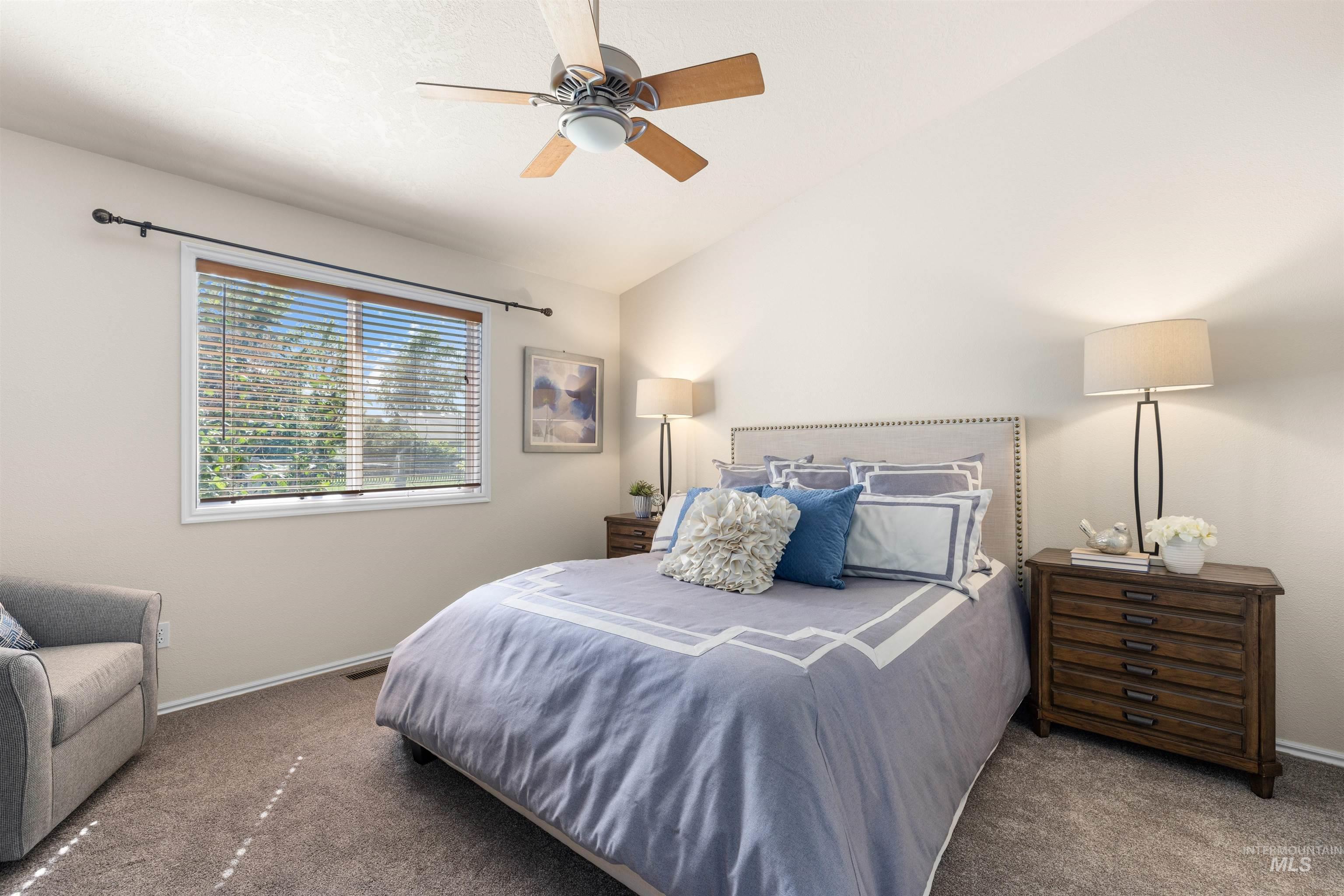Bedroom featuring vaulted ceiling, carpet floors, and ceiling fan