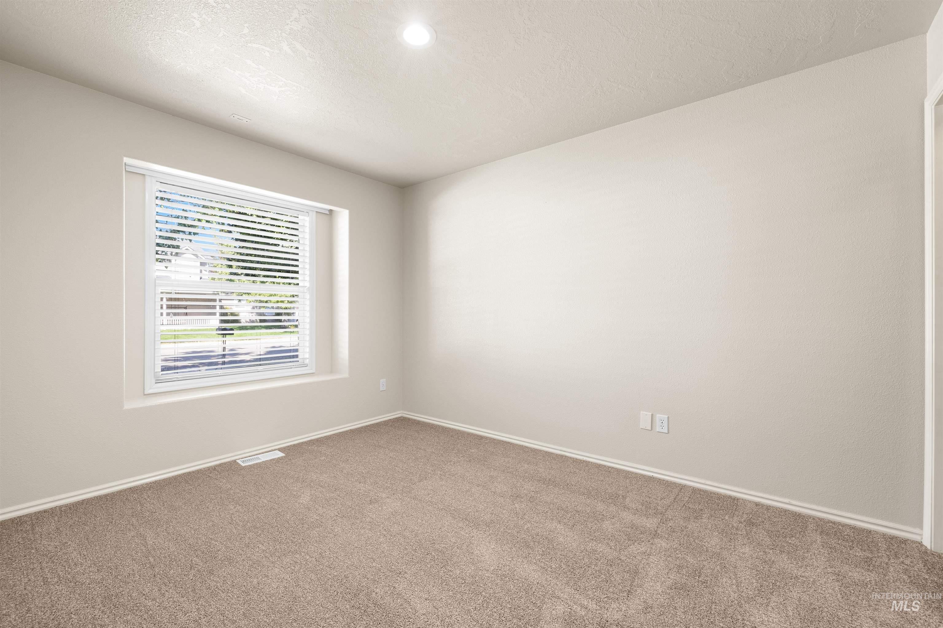 Empty room featuring carpet flooring, a textured ceiling, and recessed lighting