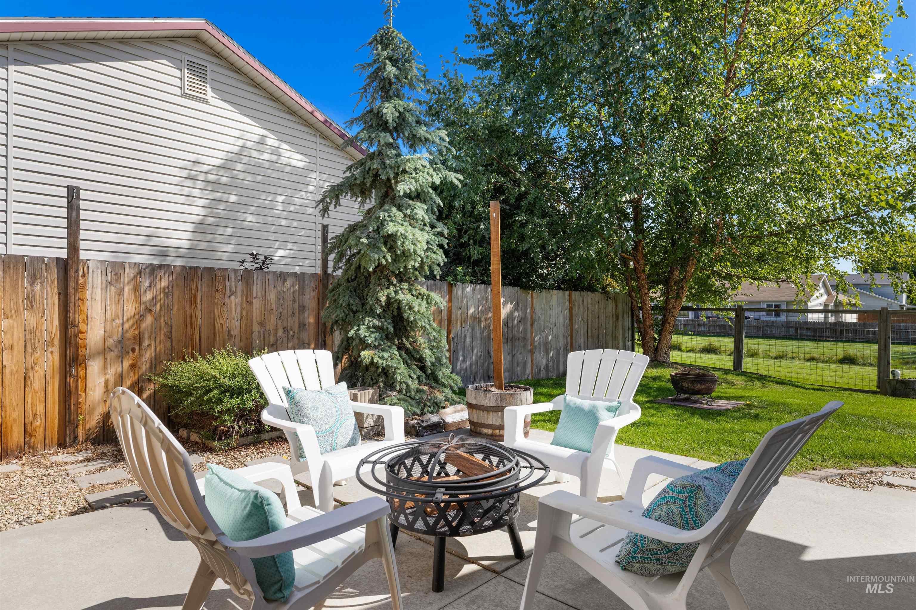 Fenced backyard with a fire pit and a patio area