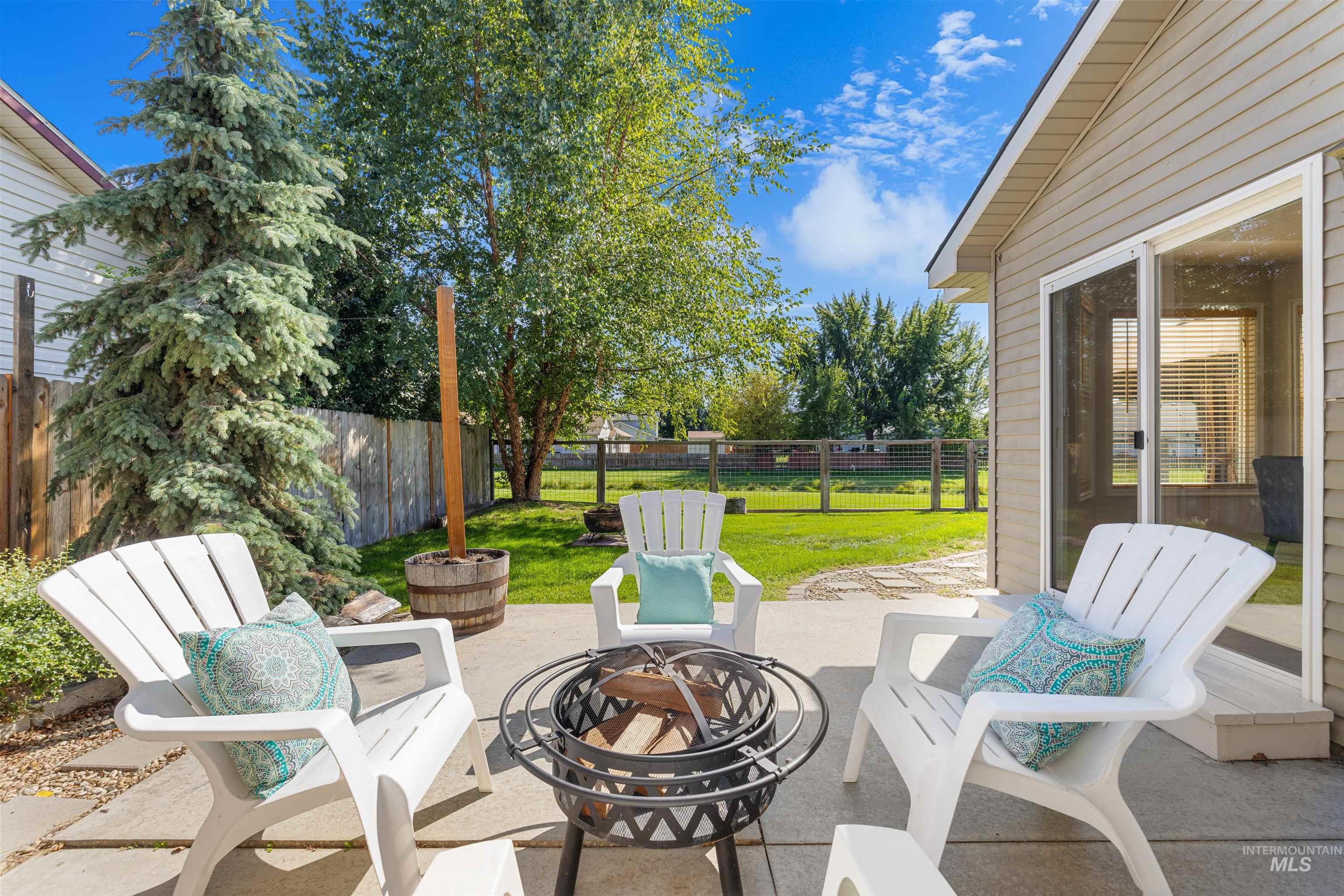 Fenced backyard featuring an outdoor fire pit and a patio area