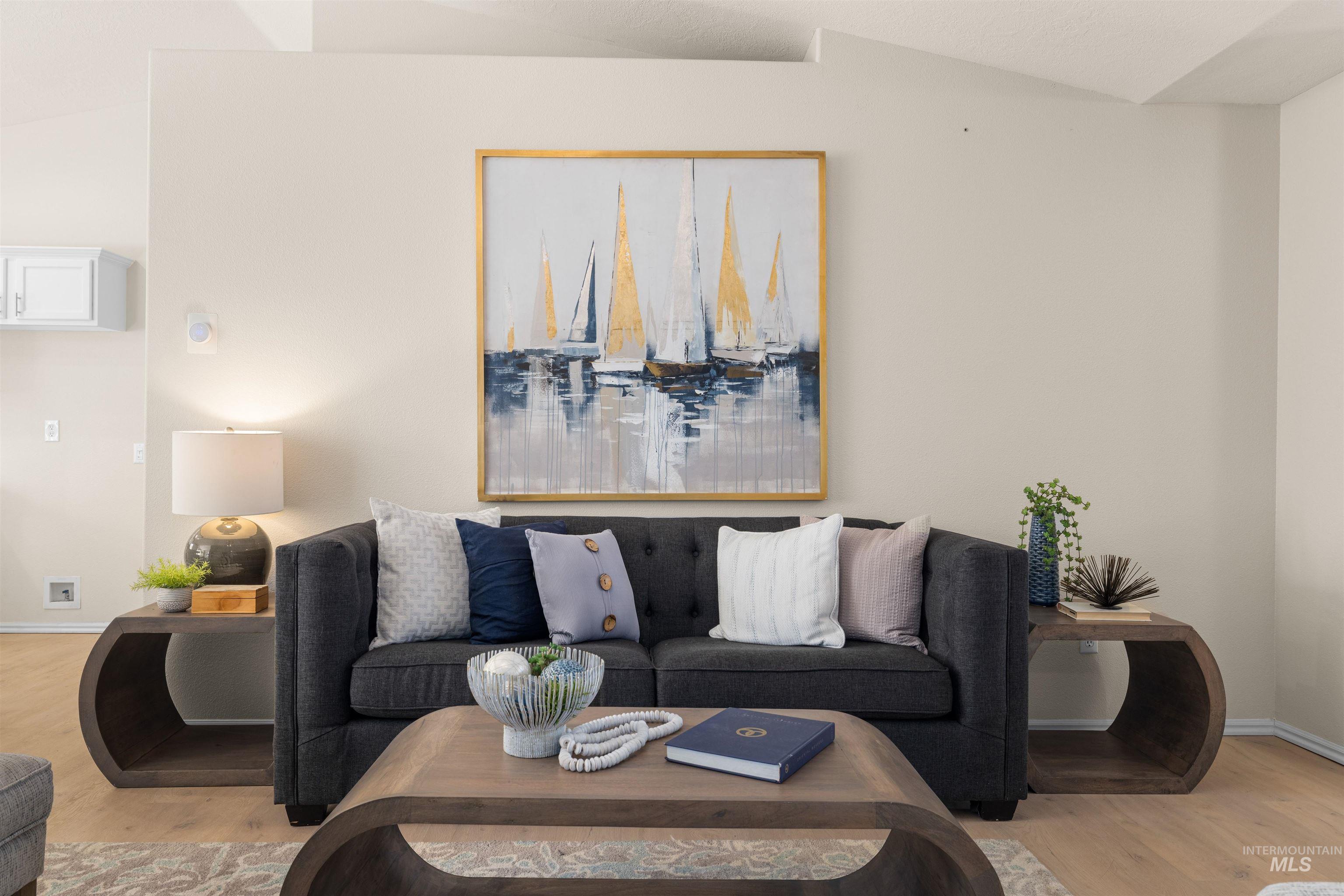 Living room featuring light wood finished floors and vaulted ceiling