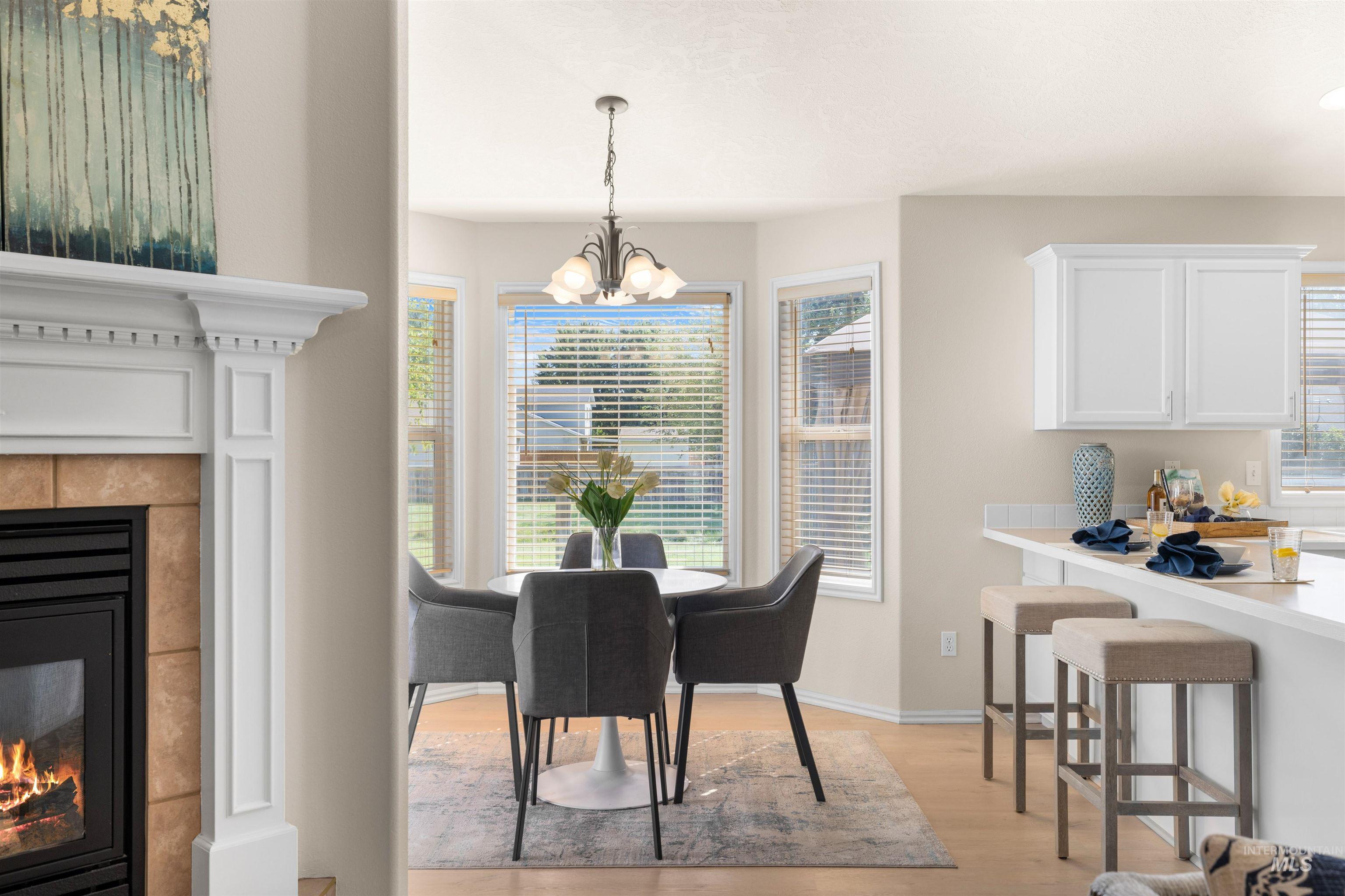 Dining space featuring a fireplace, light wood-type flooring, and a chandelier
