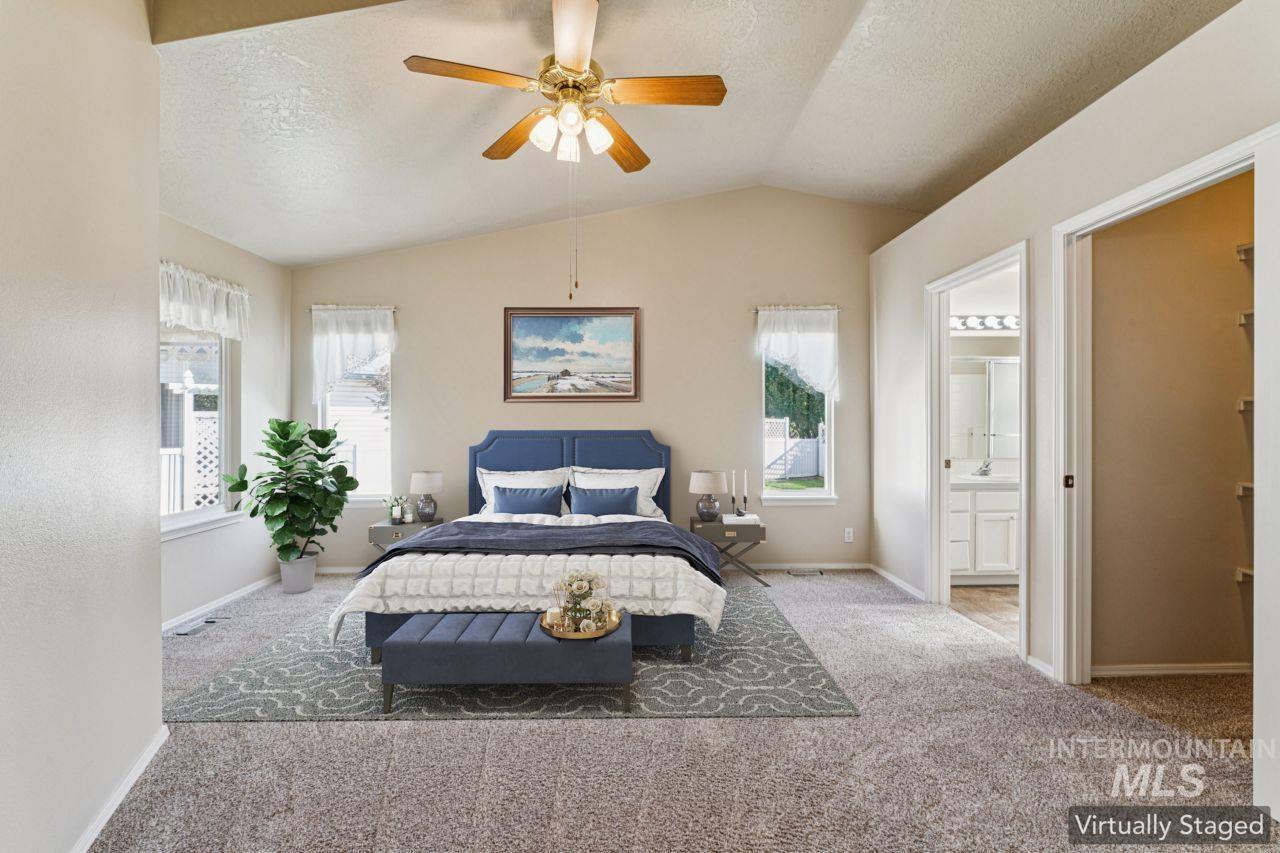 Bedroom featuring carpet flooring, a textured ceiling, vaulted ceiling, ceiling fan, and a walk in closet