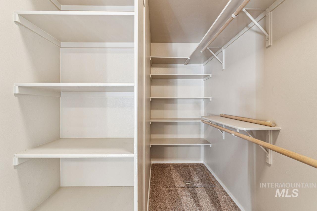 Walk in closet with dark colored carpet