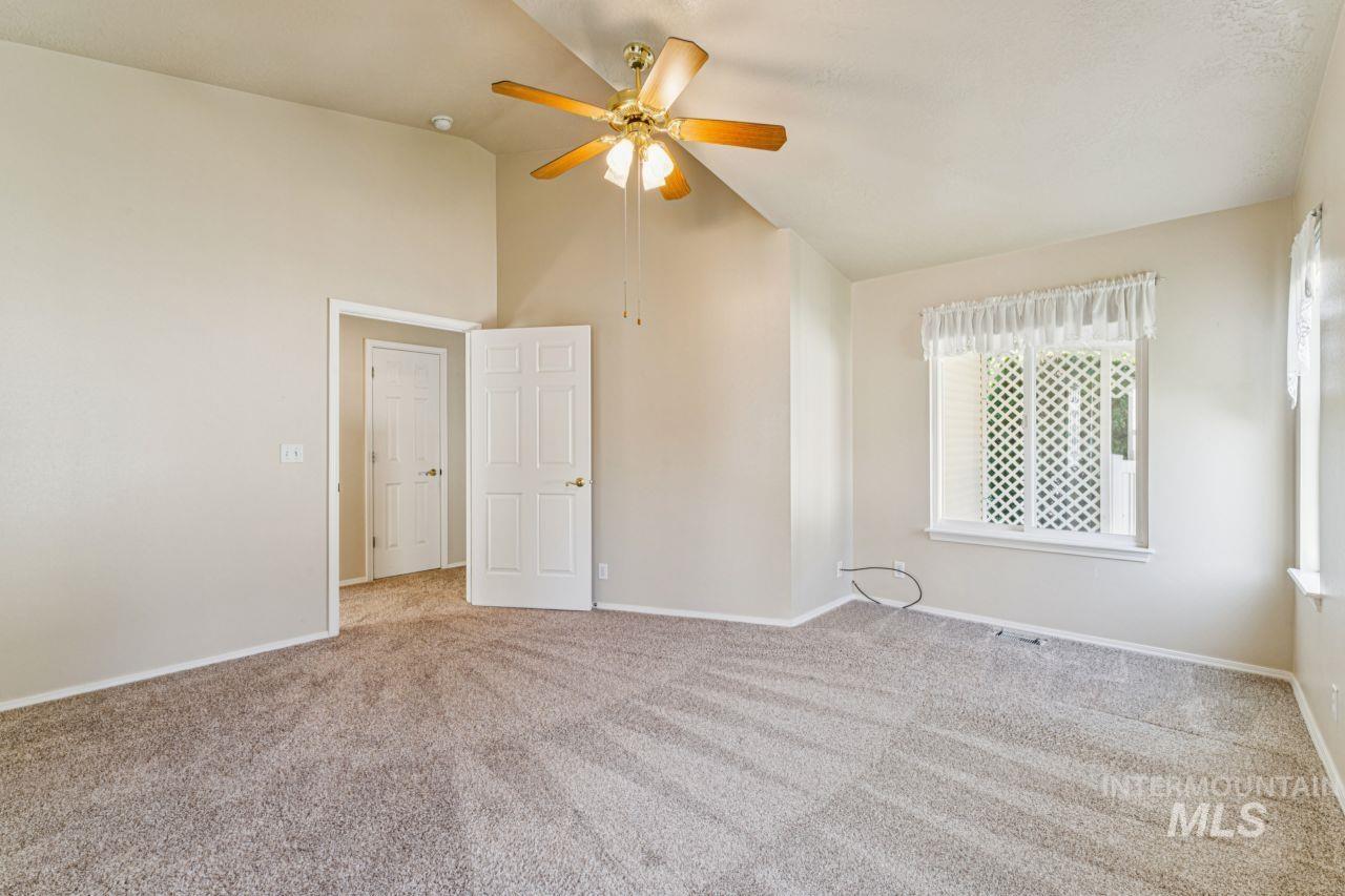 Unfurnished bedroom with carpet floors, high vaulted ceiling, and ceiling fan