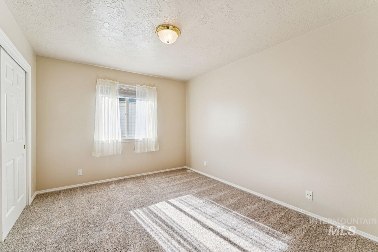Unfurnished bedroom featuring a closet, a textured ceiling, and carpet