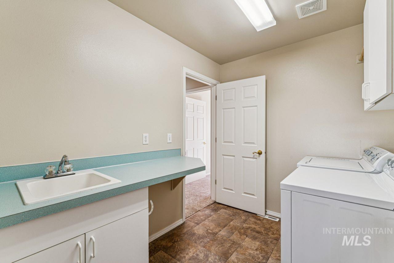 Laundry room featuring cabinet space, washing machine and dryer, and stone finish floors
