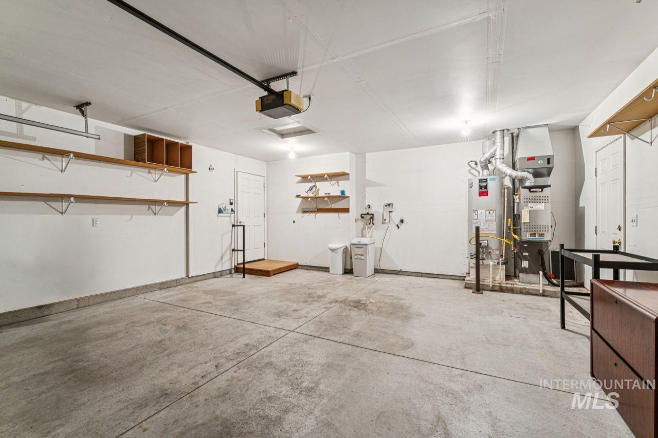 Garage featuring water heater and a garage door opener