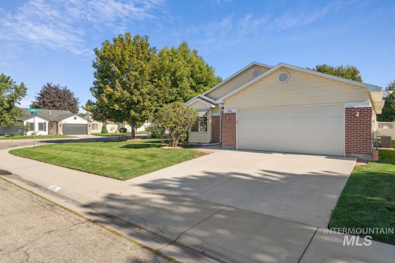 Single story home featuring brick siding, concrete driveway, a front yard, and a garage