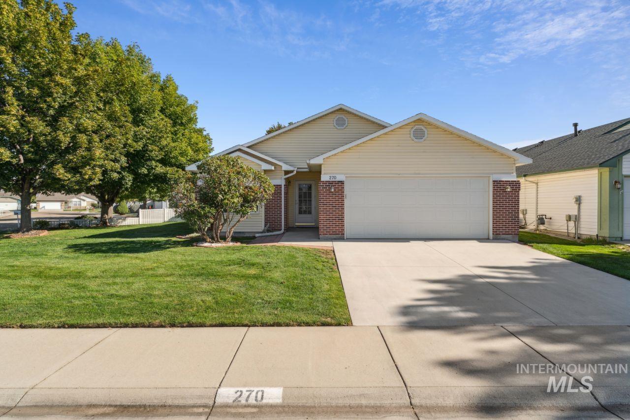 View of front of property featuring brick siding, an attached garage, driveway, and a front lawn
