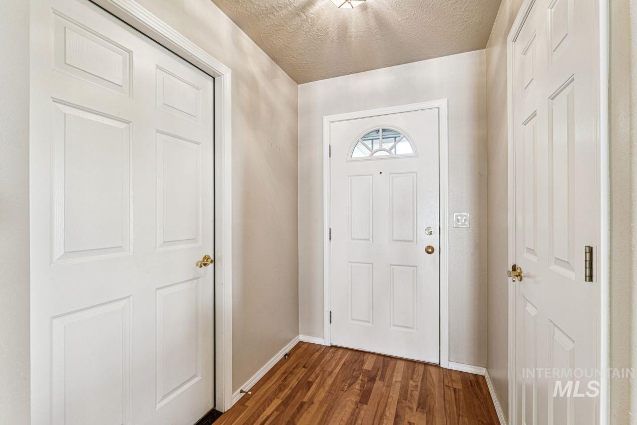 Foyer entrance with dark wood-type flooring and a textured ceiling