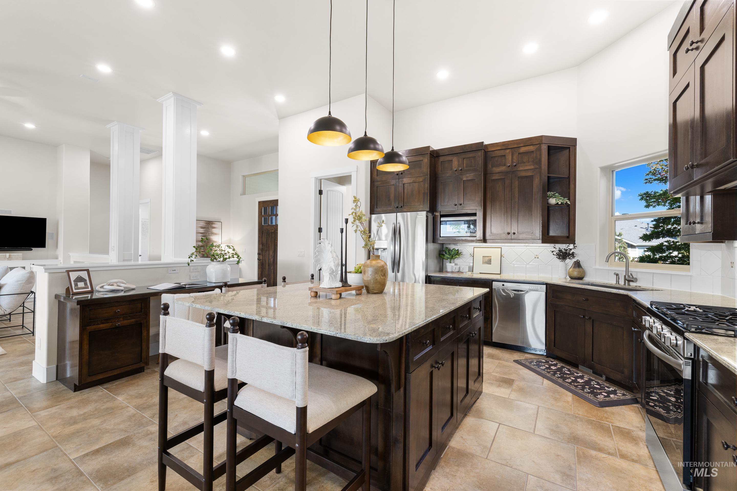 Kitchen featuring dark brown cabinetry, light stone countertops, tasteful backsplash, and recessed lighting