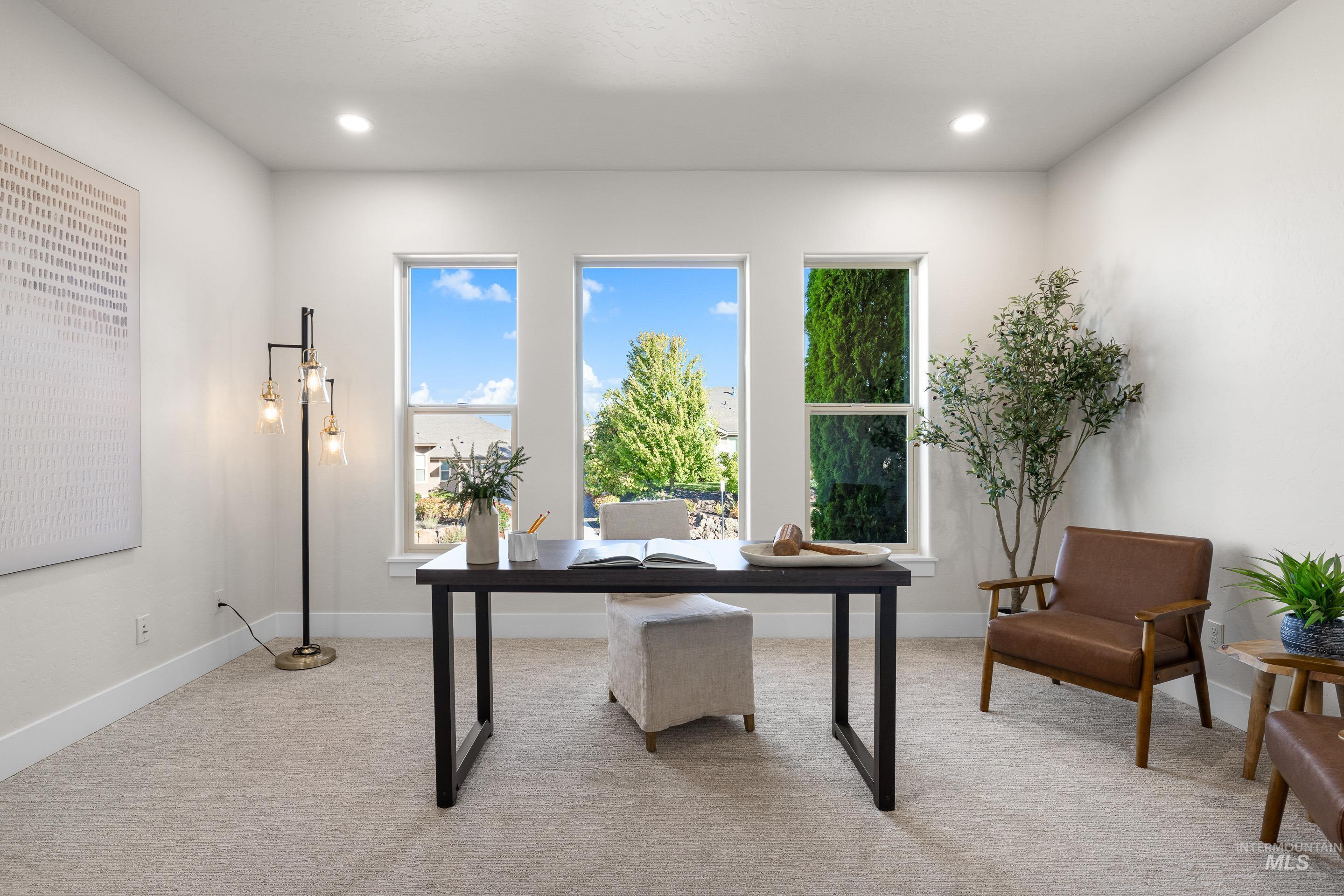 Office with light carpet and recessed lighting