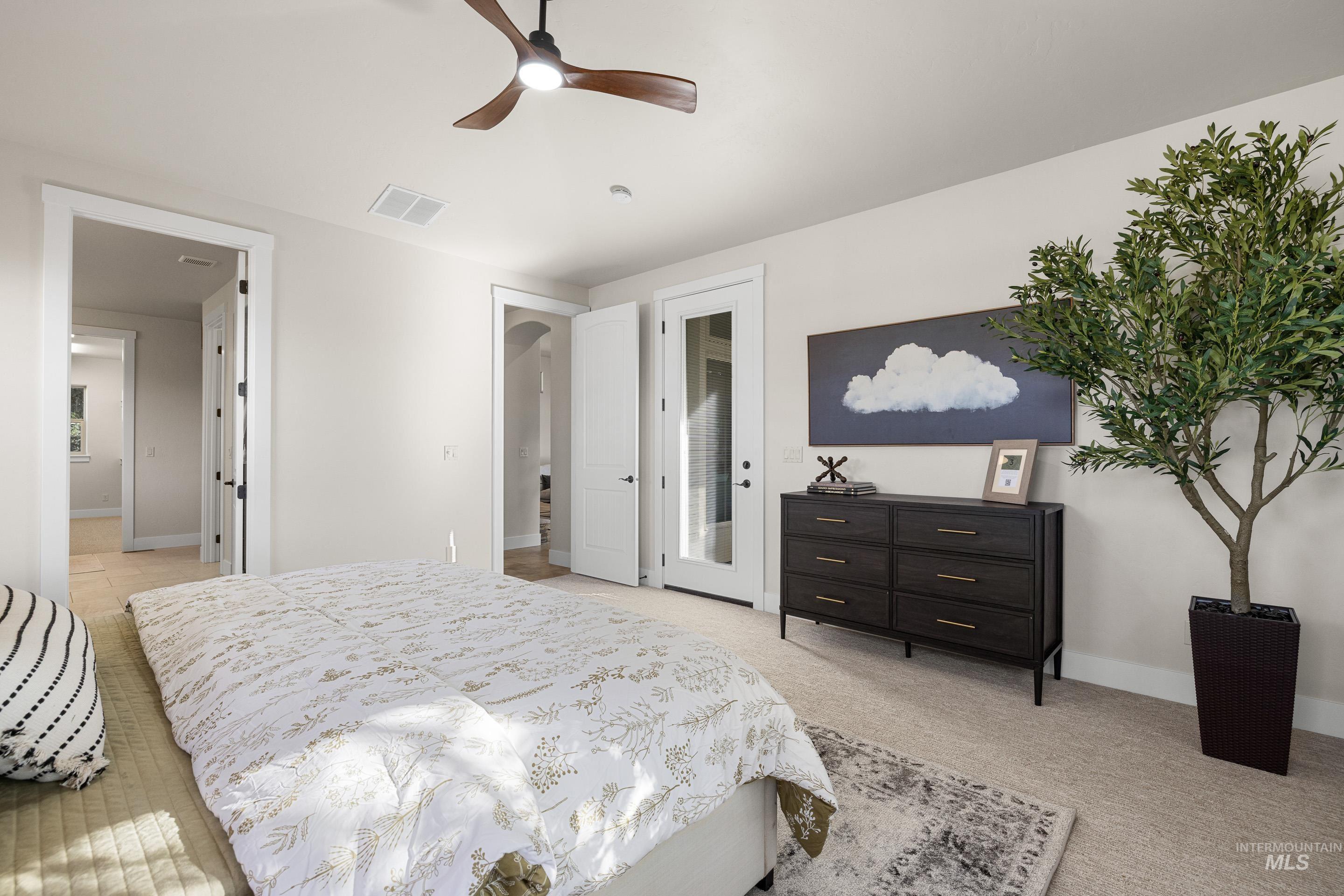 Bedroom featuring a ceiling fan, light carpet, and access to exterior
