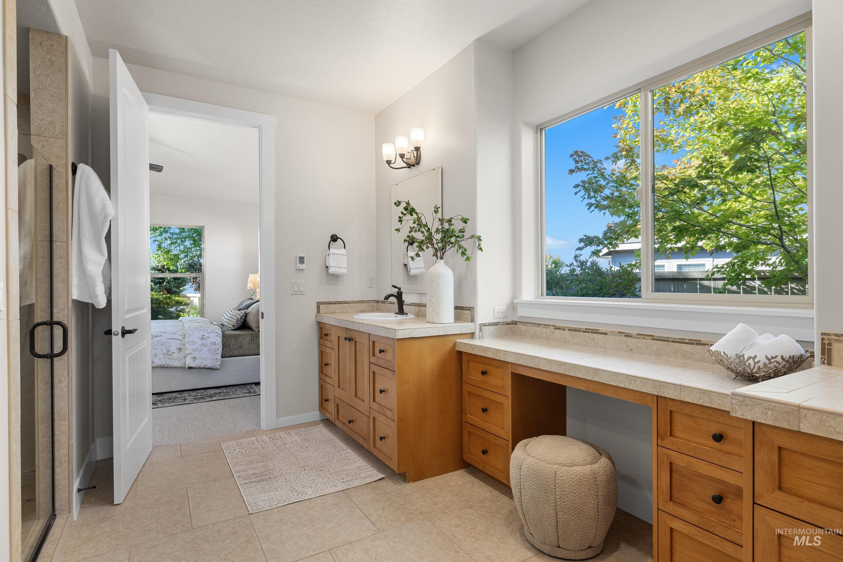 Full bath featuring ensuite bathroom, a stall shower, vanity, and light tile patterned floors