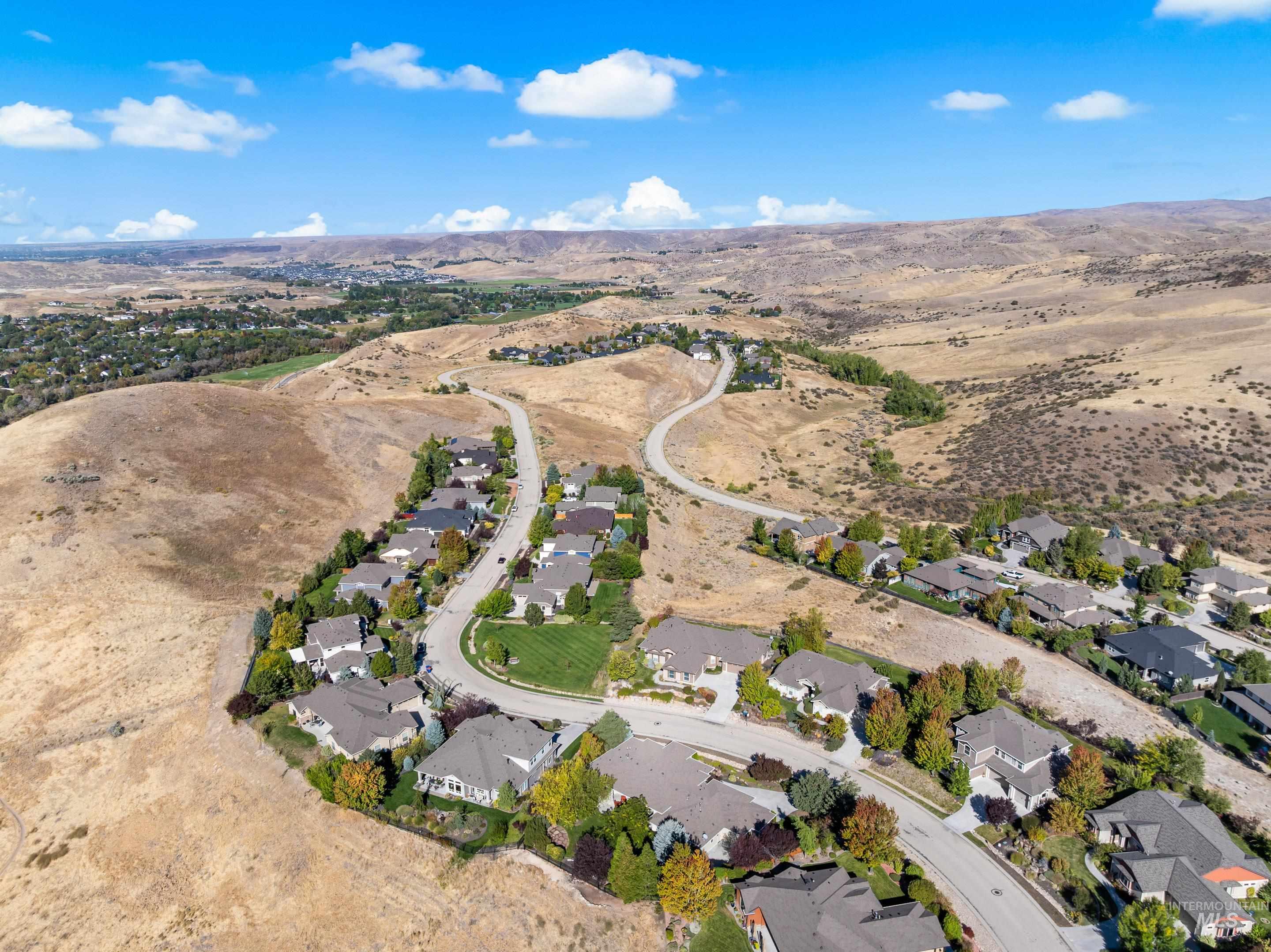 Aerial view of property's location with nearby suburban area and a mountain backdrop