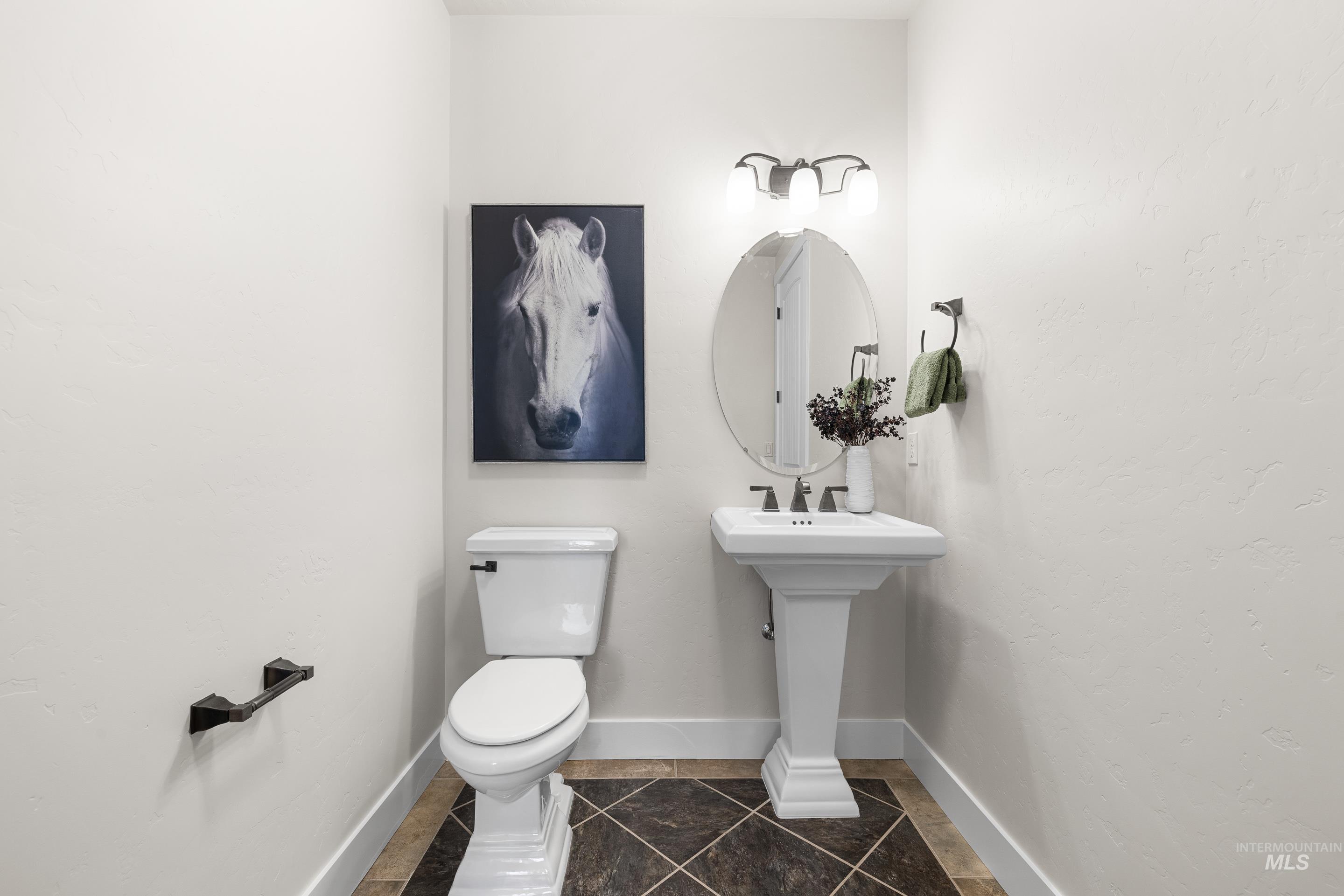 Bathroom featuring dark tile patterned flooring and baseboards